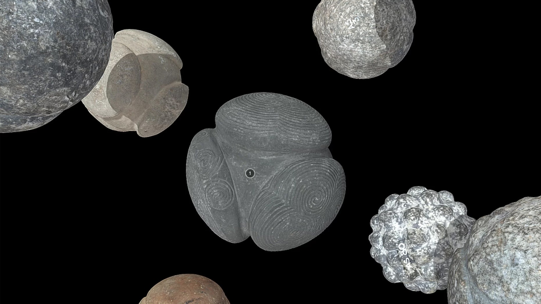 The 3D models of the carved balls of stone, including the spiral-carved Towie ball (center), are now posted online. Credit: National Museums Scotland