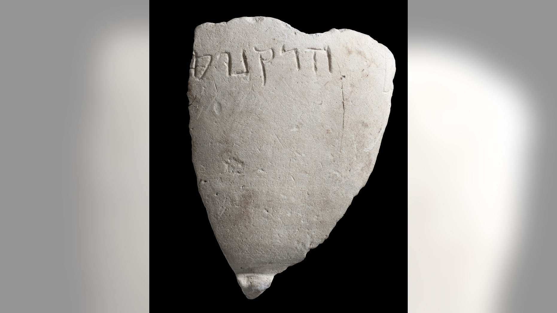 A fragment of the chalk bowl from the Hasmonean period, which is engraved with the name “Hyrcanus”. (Photographic credit: Clara Amit, Israel Antiquities Authority)