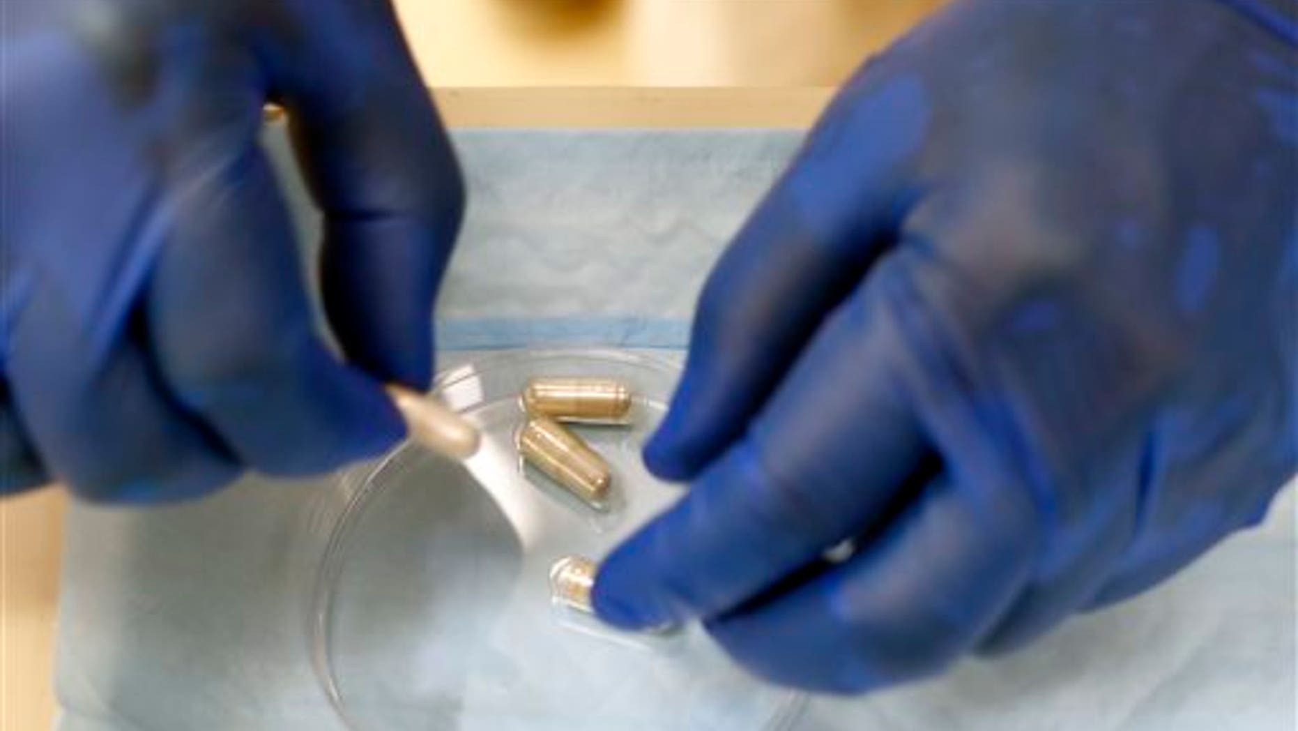 Dr. Thomas Louie, an infectious disease specialist at the University of Calgary, prepares stool pills in his lab in Calgary, Alberta, Canada on Thursday, Sept. 26, 2013.