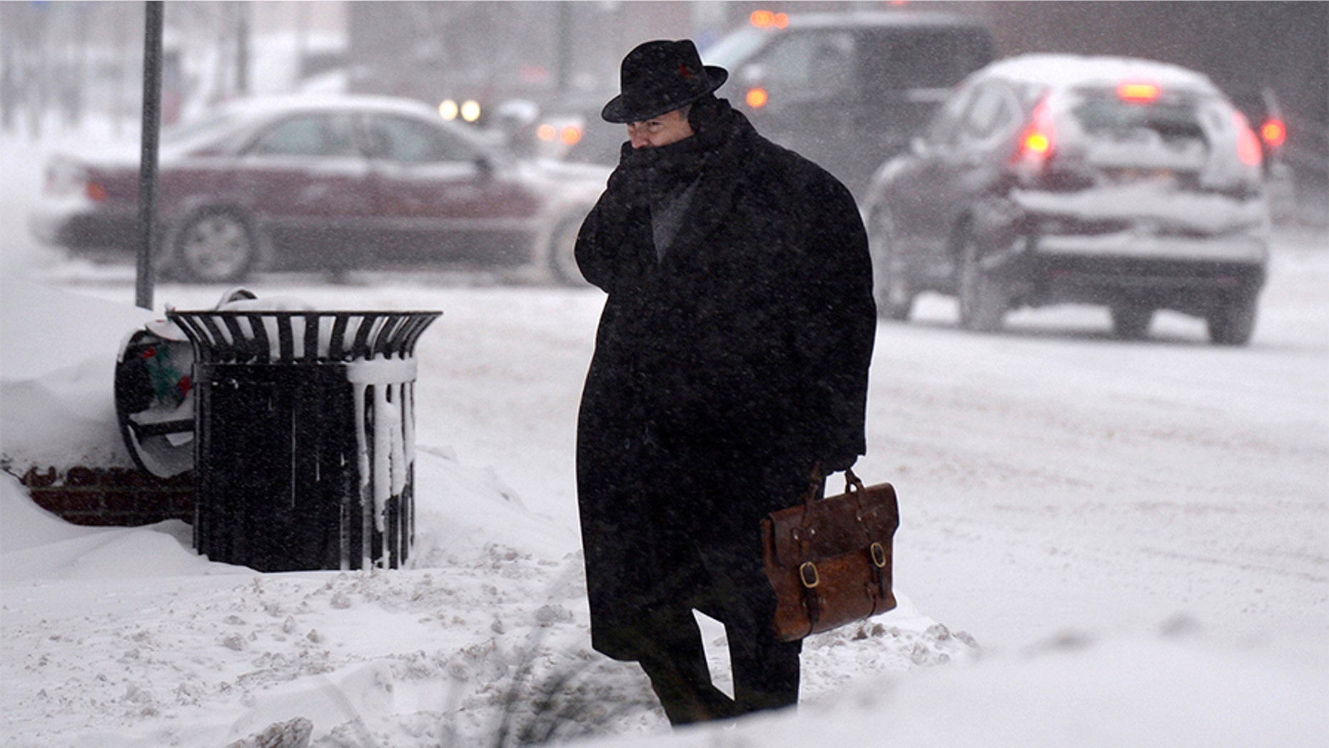 A man crosses street in downtown Syracuse, N.Y., Friday. Frigid temperatures, some that felt as cold as minus 30 degrees, moved across the East Coast on Friday as the region dug out from a massive winter storm.