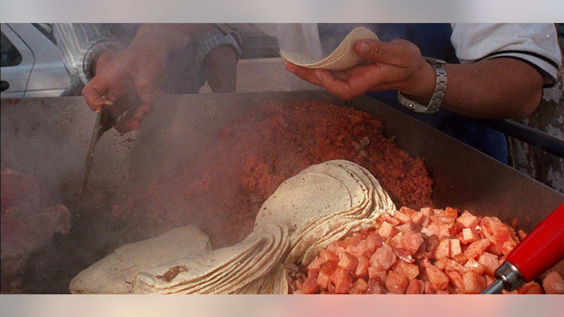 Mexican taco vendor Marcelo Garcia serves a taco to customer Guillermo Nunez in Mexico City, Mexico Wednesday Jan. 19, 2000. Mexico is declaring illegal plans by a group of tortilla producers to raise the price of the Mexican dietary staple by more than 14 percent, and says it may file price-fixing charges against the producers.(AP Photo/Marco Ugarte)