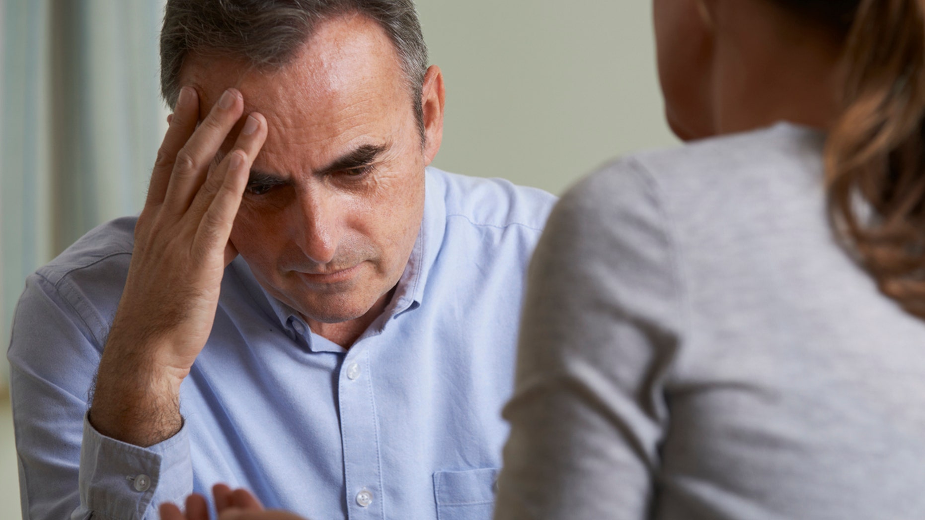 Depressed Mature Man Talking To Counsellor