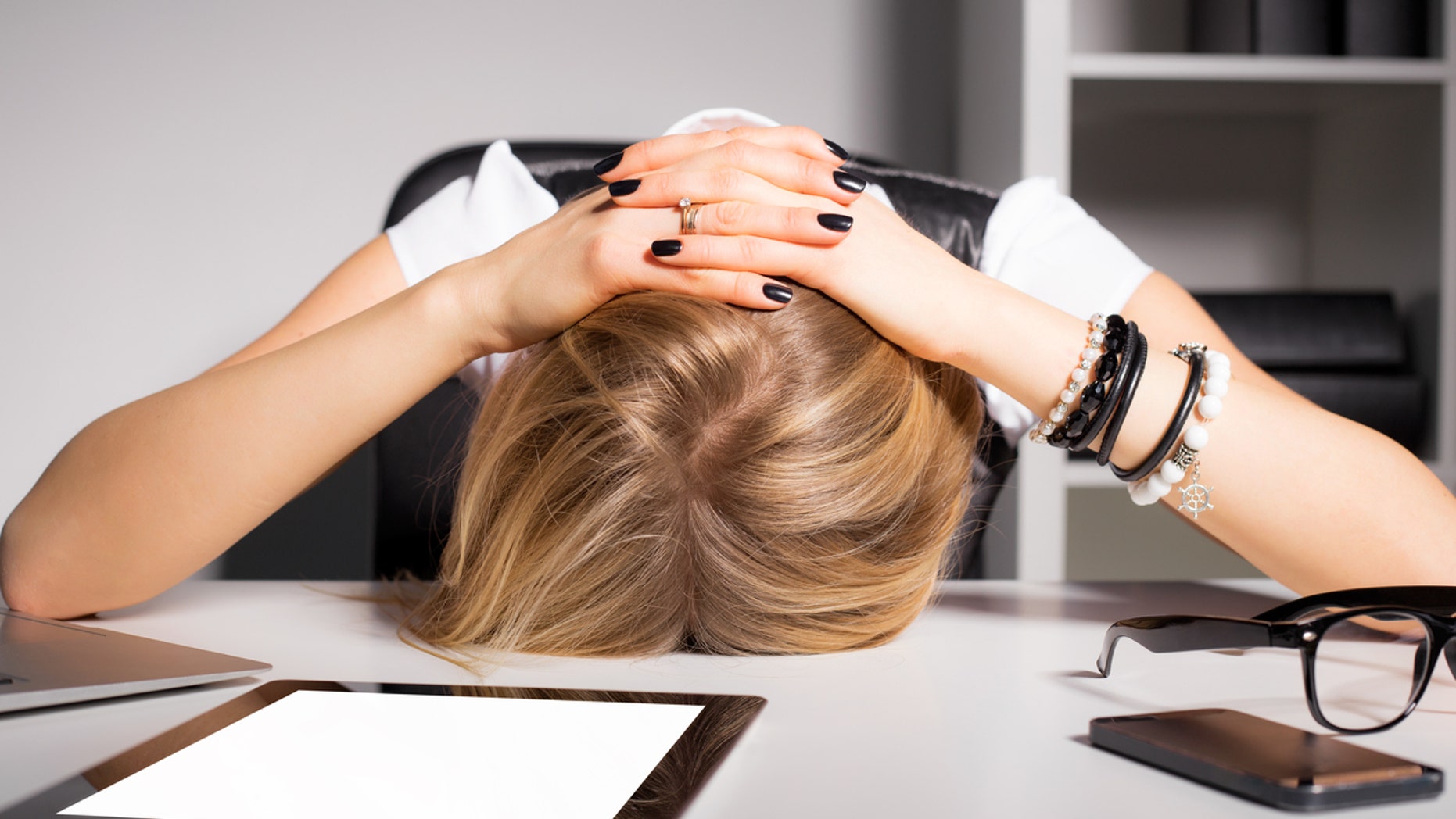 Tired business woman resting her head on desk