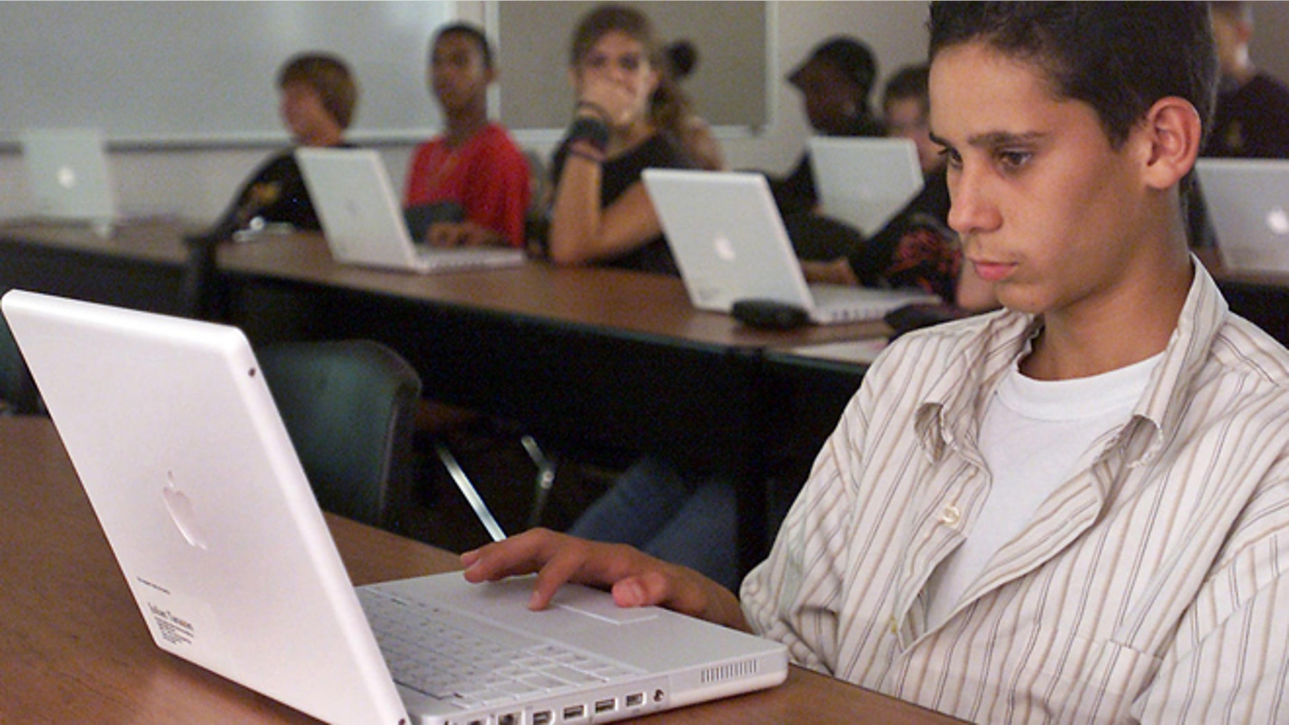 A student works with his Apple laptop in class at Empire High School in Vail, Ariz.