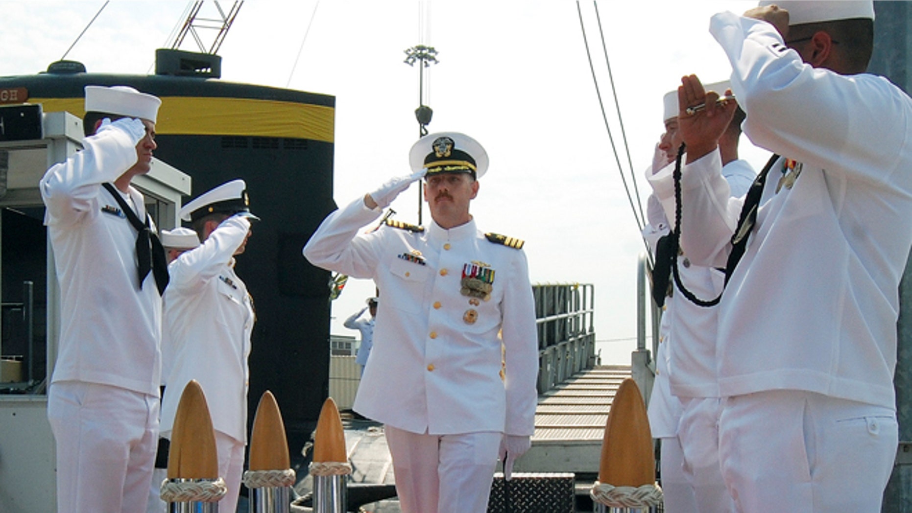 Aug. 3, 2013: In this photo provided by the U.S. Navy, Cmdr. Michael P. Ward II, center, is saluted during the change-of-command ceremony for the nuclear submarine USS Pittsburgh at the Naval Submarine Base New London, in Groton, Conn.