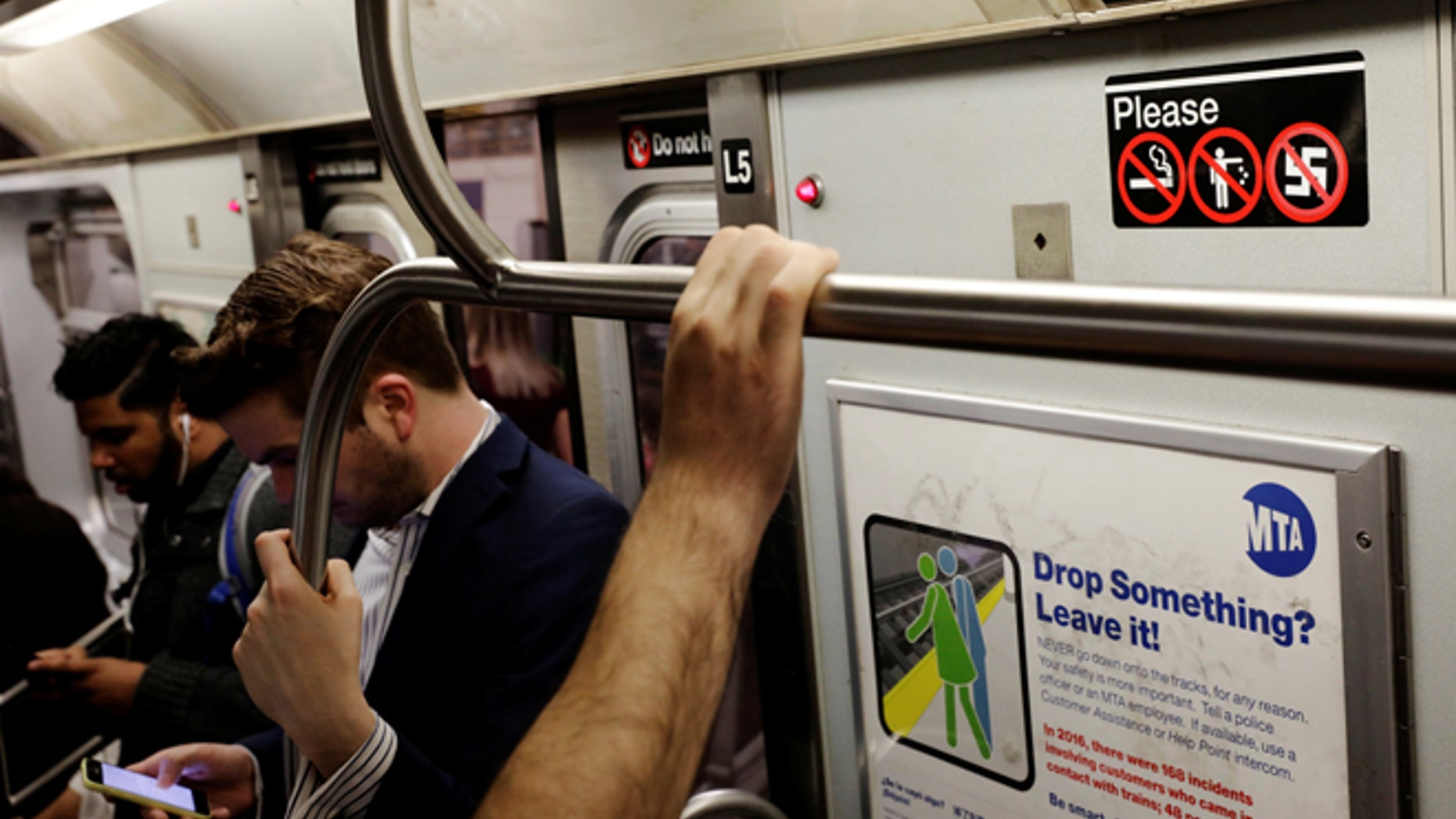 Commuters stand on a subway train near an anti-nazi sticker in New York, U.S., June 19, 2017. REUTERS/Lucas Jackson - RTS17QN1