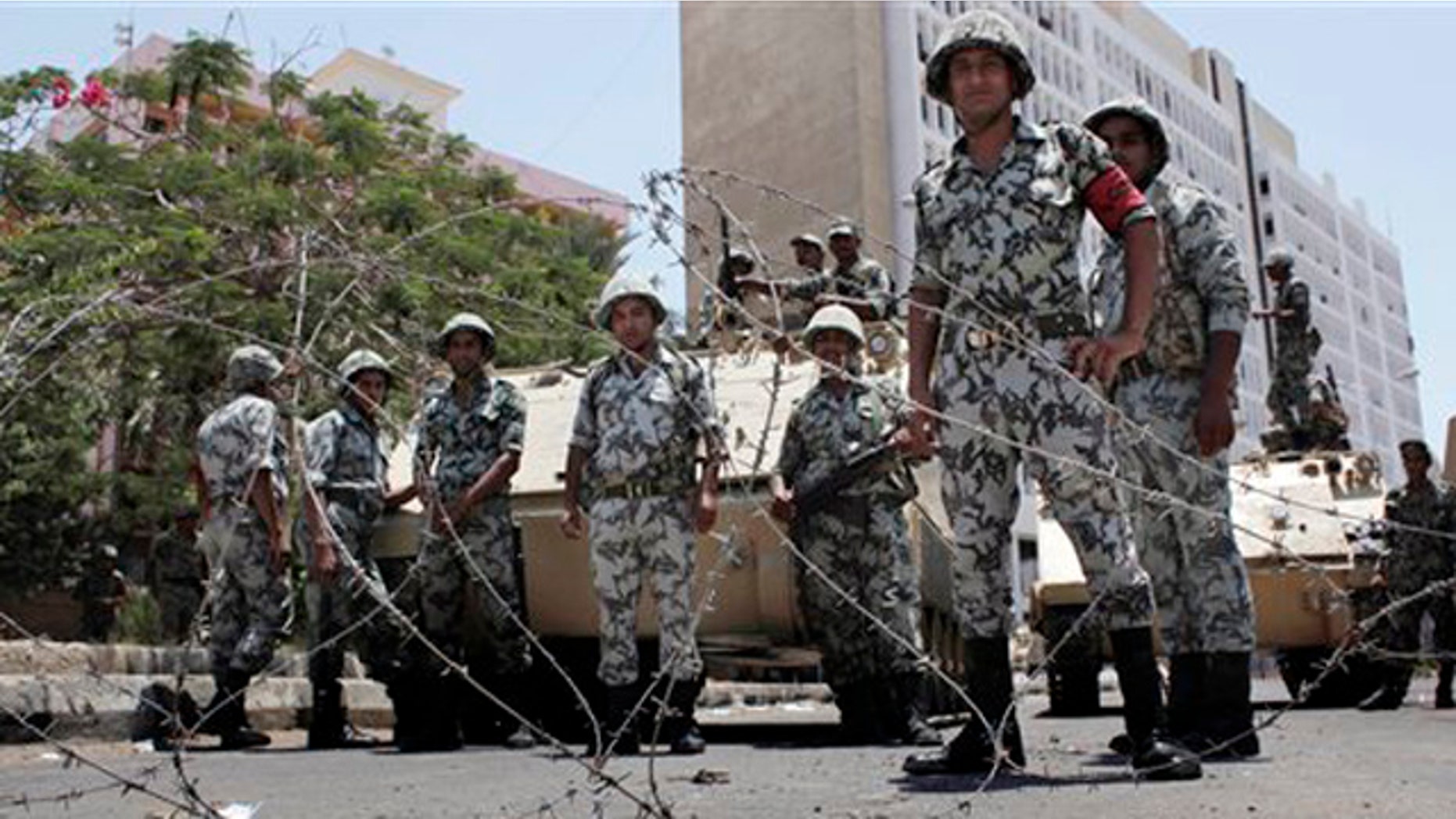 Egyptian army soldiers secure the Suez governate and the former state security headquarters, both in the background as the military deployed reinforcements to secure strategic facilities during a demonstration, part of nationally organized protest, in Suez, Egypt Friday, July 8, 2011.