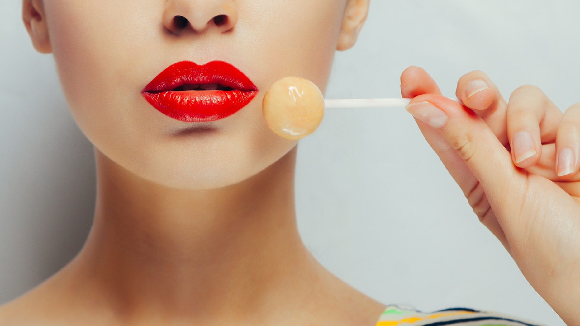 Young beautiful girl with lollipop in her mouth