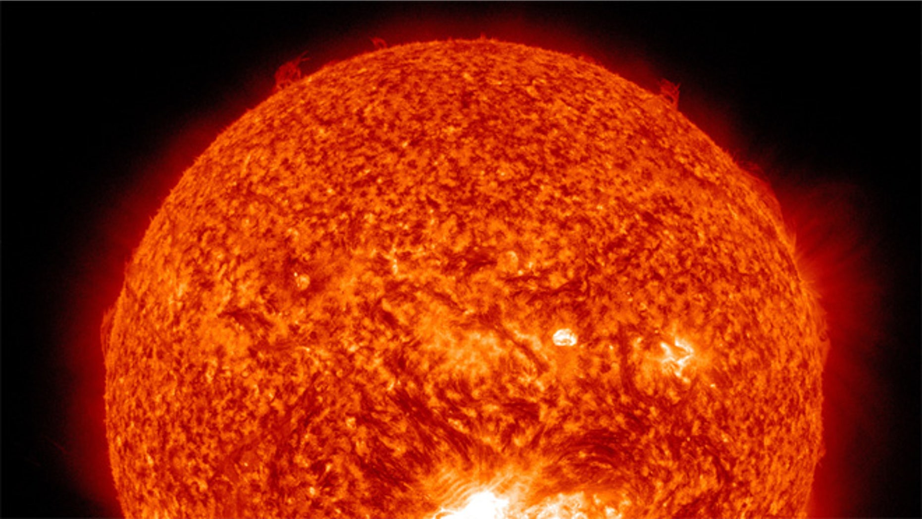 This image from the Solar Dynamics Observatory (SDO) shows the sun at 12:45 PM EDT on July 12, 2012 during an X1.4 class flare. The image is captured in the 304 Angstrom wavelength, which is typically colorized in red and shows temperatures in the 50,000 Kelvin range.