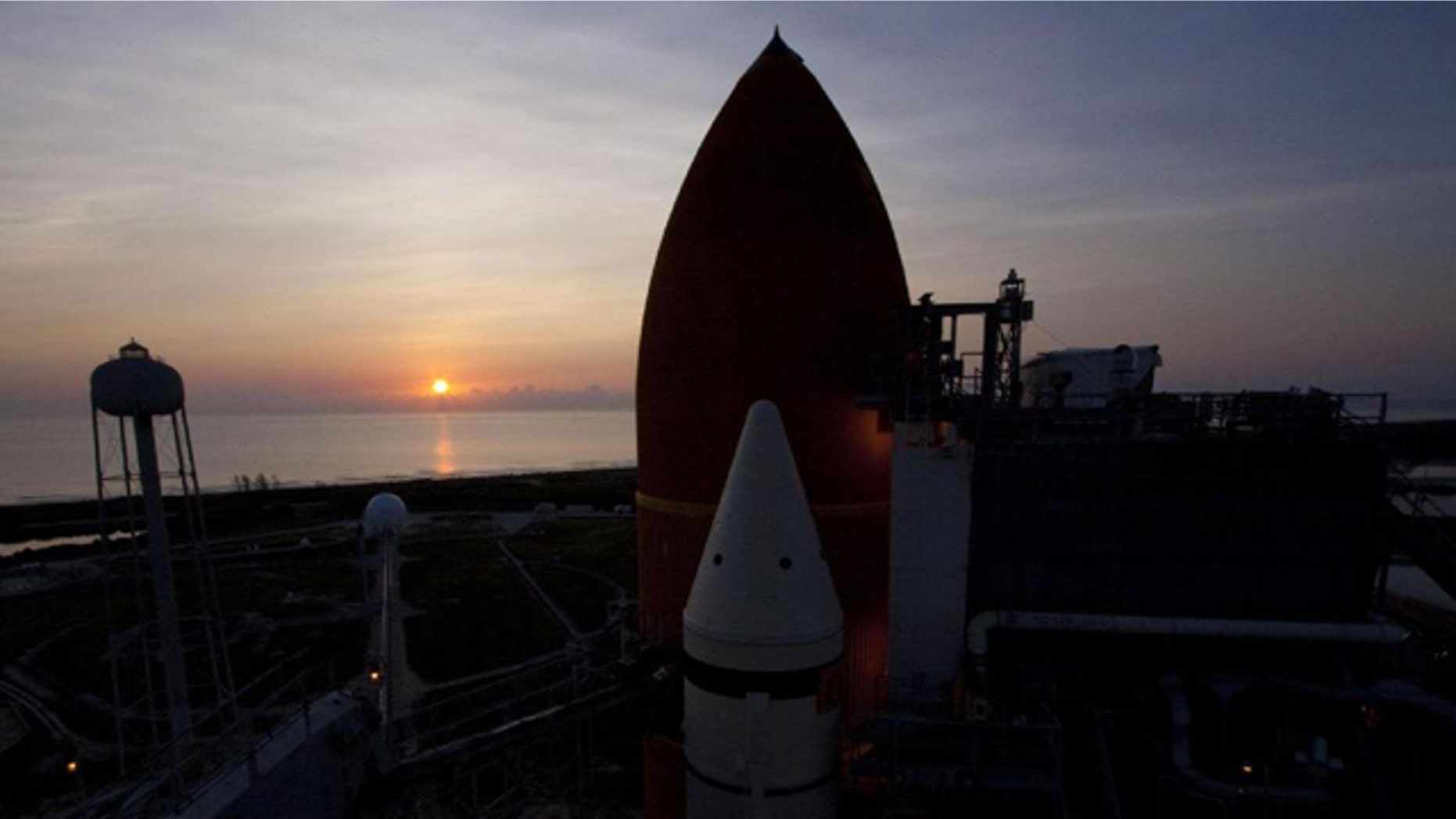 The sun rises over the Atlantic Ocean at NASA's Kennedy Space Center in Florida, illuminating space shuttle Atlantis' external fuel tank and solid rocket boosters on Launch Pad 39A. Launch is scheduled to take place for the STS-135 mission on July 8, 2011. This image was taken on June 23, 2011.