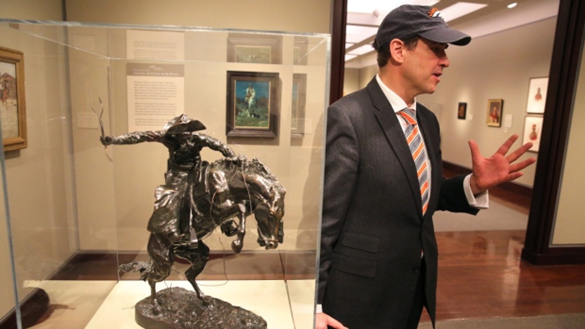 January 29, 2014: Denver Art Museum director Christoph Heinrich poses next to a Frederic Remington bronze of a cowboy riding a bucking horse, part of the museum's collection. The Denver and Seattle Art Museums have started a friendly wager: if the Broncos win the Super Bowl against the Seahawks, Seattle will send a Seahawk mask to Denver for three months. If the Seahawks win, Denver sends the Remington statue to Seattle for three months. (Brennan Linsley/Associated Press)