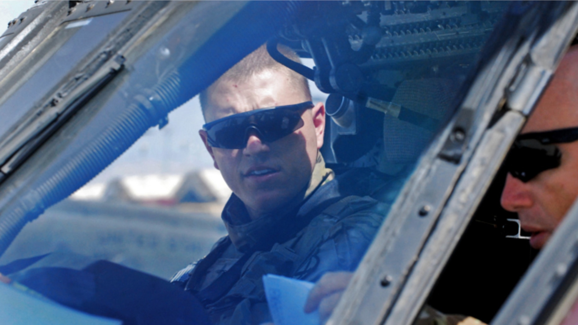 FILE: Sept. 10, 2013: U.S. Army 1st. Lt. Chuck Nadd, left, and U.S. Army Chief Warrant Officer 4 Darren Dreher perform start-up procedures inside the cockpit of a UH-60 Black Hawk helicopter at Bagram Air Field in Afghanistan.