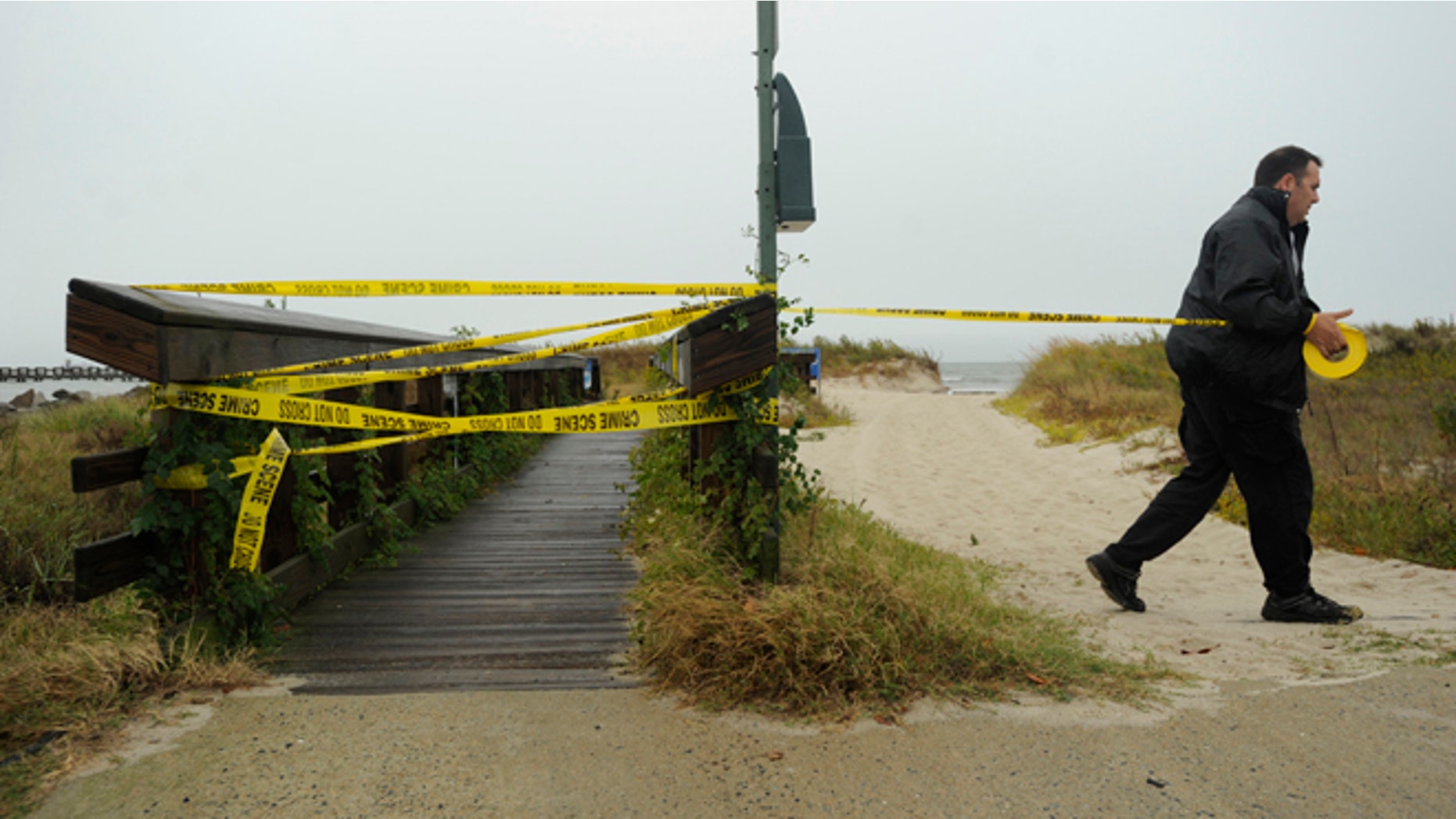 Oct. 28, 2012: Cape Charles Police Officer Jim Pruitt tapes off the town fishing pier and beach to restrict access in Cape Charles, Va., ahead of Hurricane Sandy.