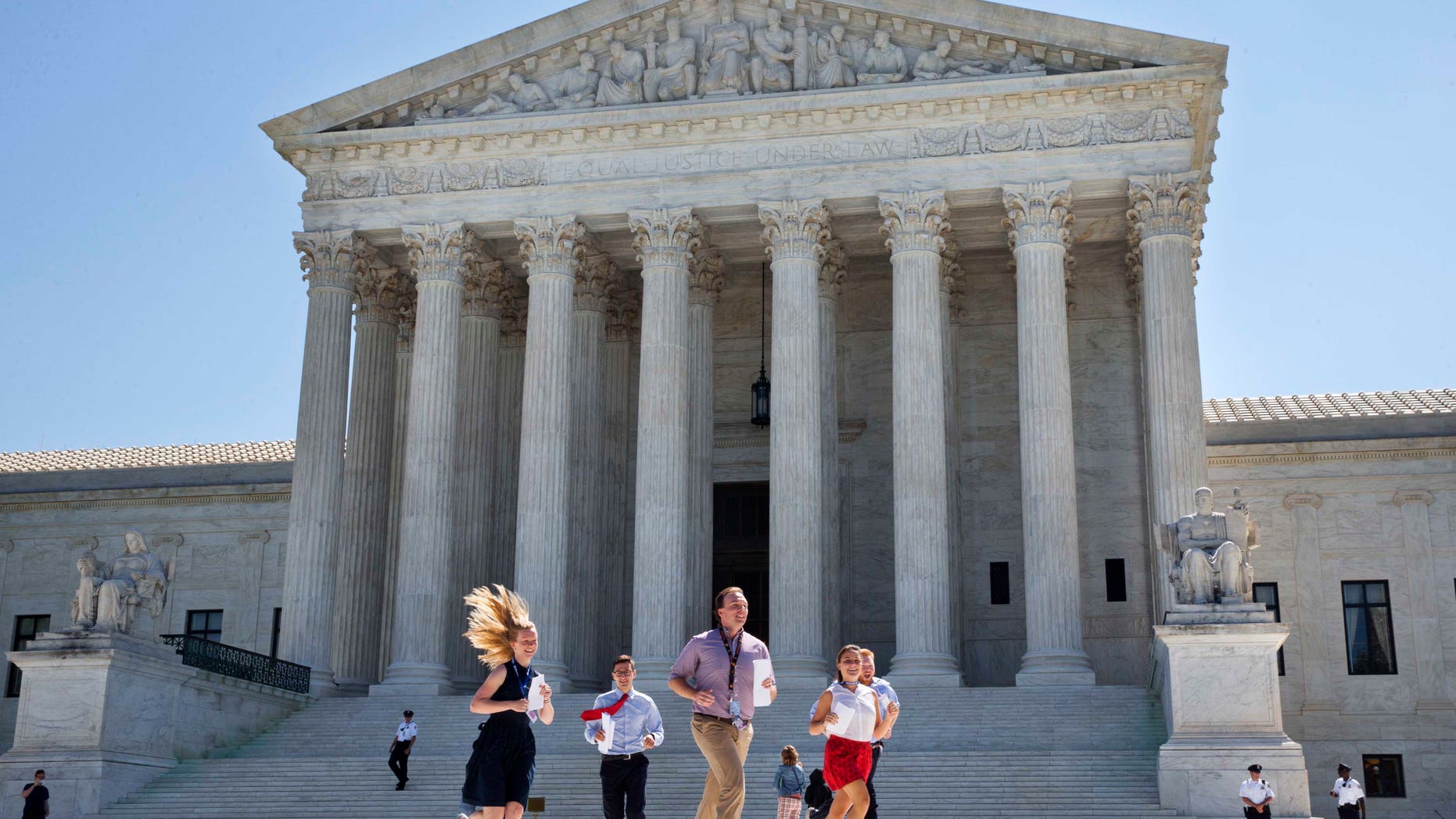 New interns run with a decision across the plaza of the Supreme Court in Washington, Monday June 29, 2015. On Monday, the court upheld Arizona congressional districts drawn by an independent commission and rejected a constitutional challenge from Republican lawmakers and upheld the use of a controversial drug in lethal injection executions Monday, as two dissenting justices said for the first time that they think it's "highly likely" that the death penalty itself is unconstitutional. (AP Photo/Jacquelyn Martin)