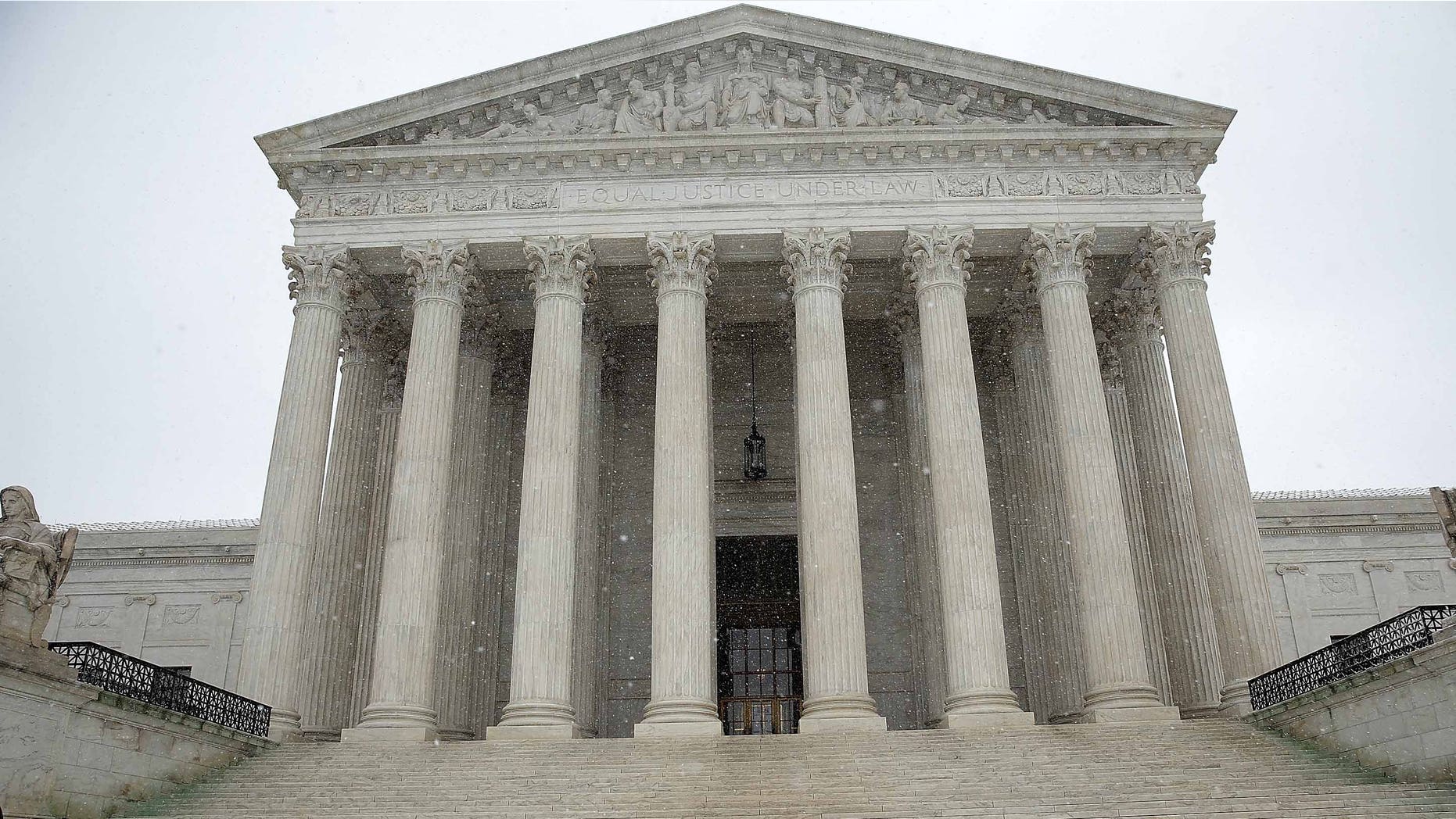 WASHINGTON, DC - MARCH 05: A government employee shovels newly fallen snow from the steps of the U.S. Supreme Court March 5, 2015 in Washington, DC. The Washington DC area is expected to receive 4-8 inches of snow during the day. (Photo by Win McNamee/Getty Images)