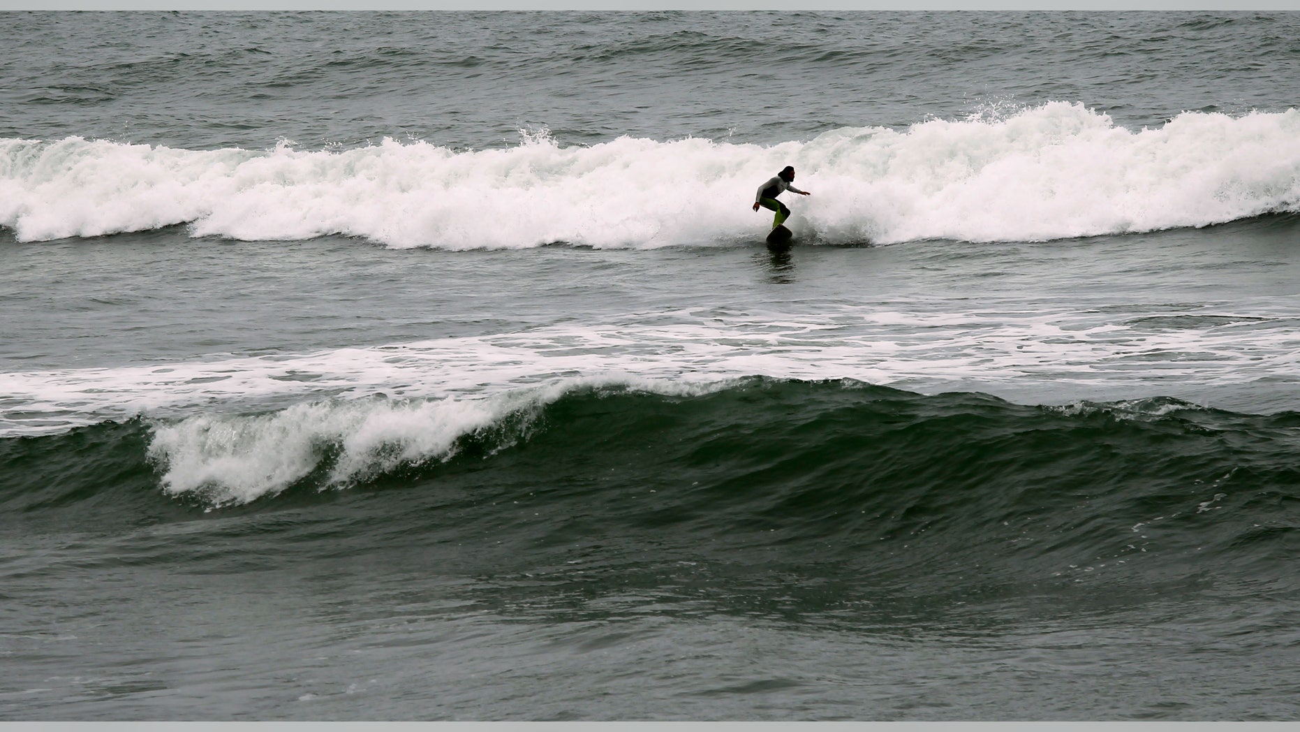 Surfer Joao Demacedo rides a wave at Martin's Beach, a popular surfing and fishing spot, in Half Moon Bay, California.