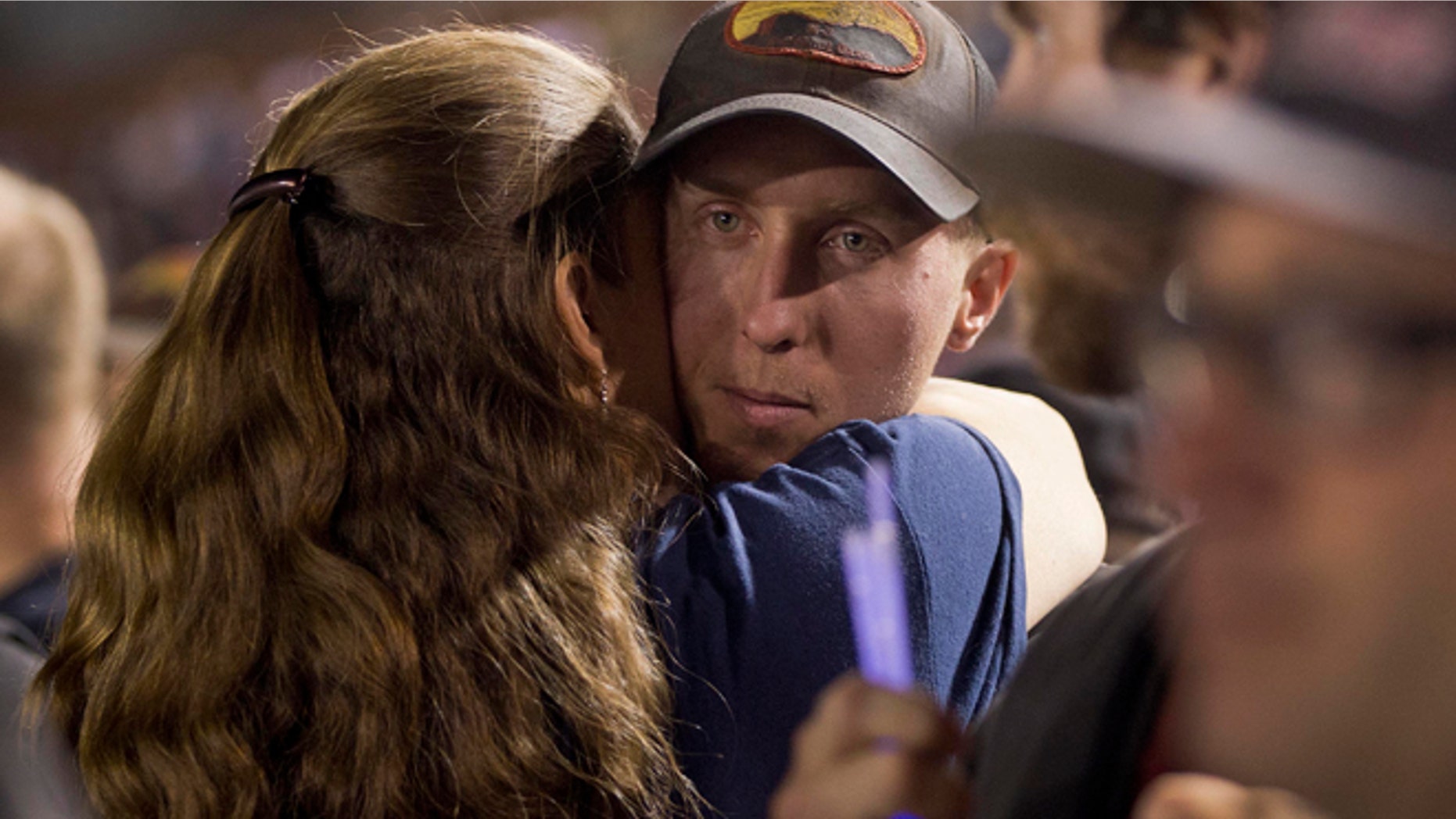 July 2: Firefighter Brendan McDonough embraces a mourner near the end of a candlelight vigil in Prescott, Ariz.
