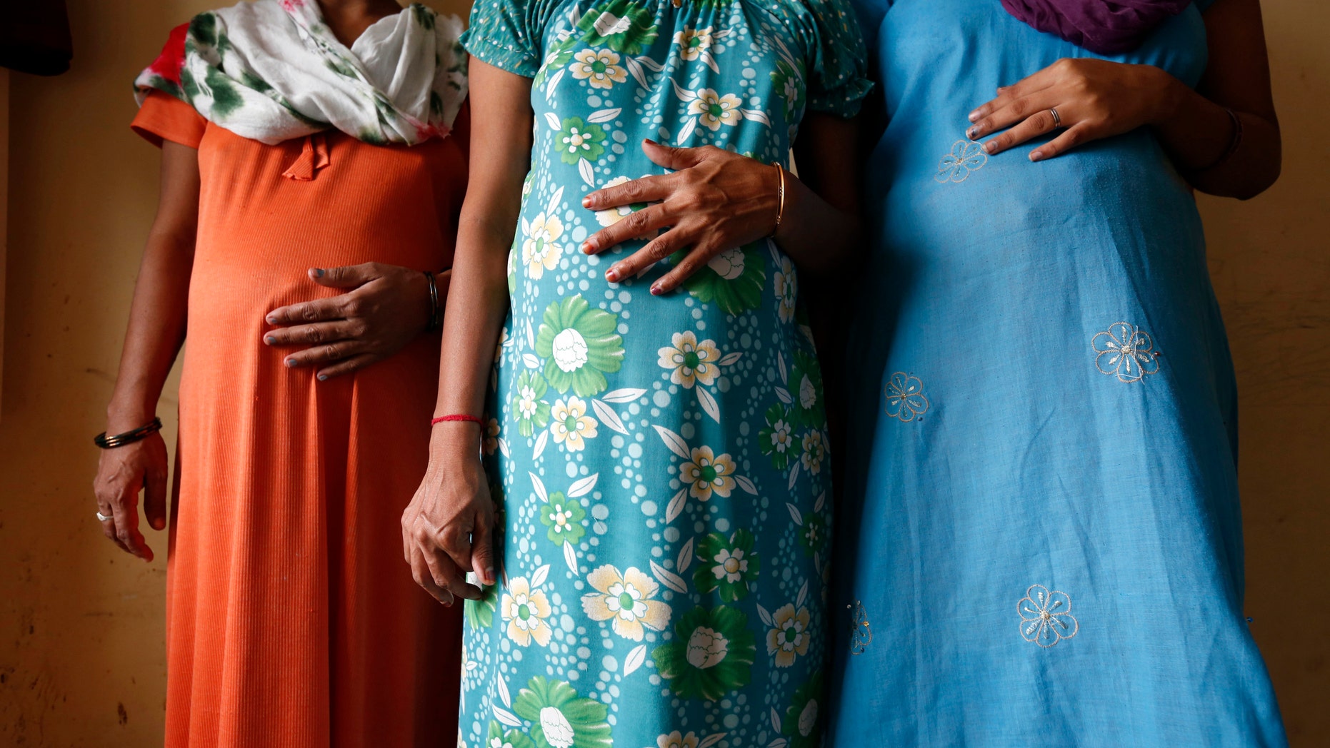 Surrogate mothers (L-R) Daksha, 37, Renuka, 23, and Rajia, 39, pose for a photograph inside a temporary home for surrogates in India (REUTERS/Mansi Thapliyal).