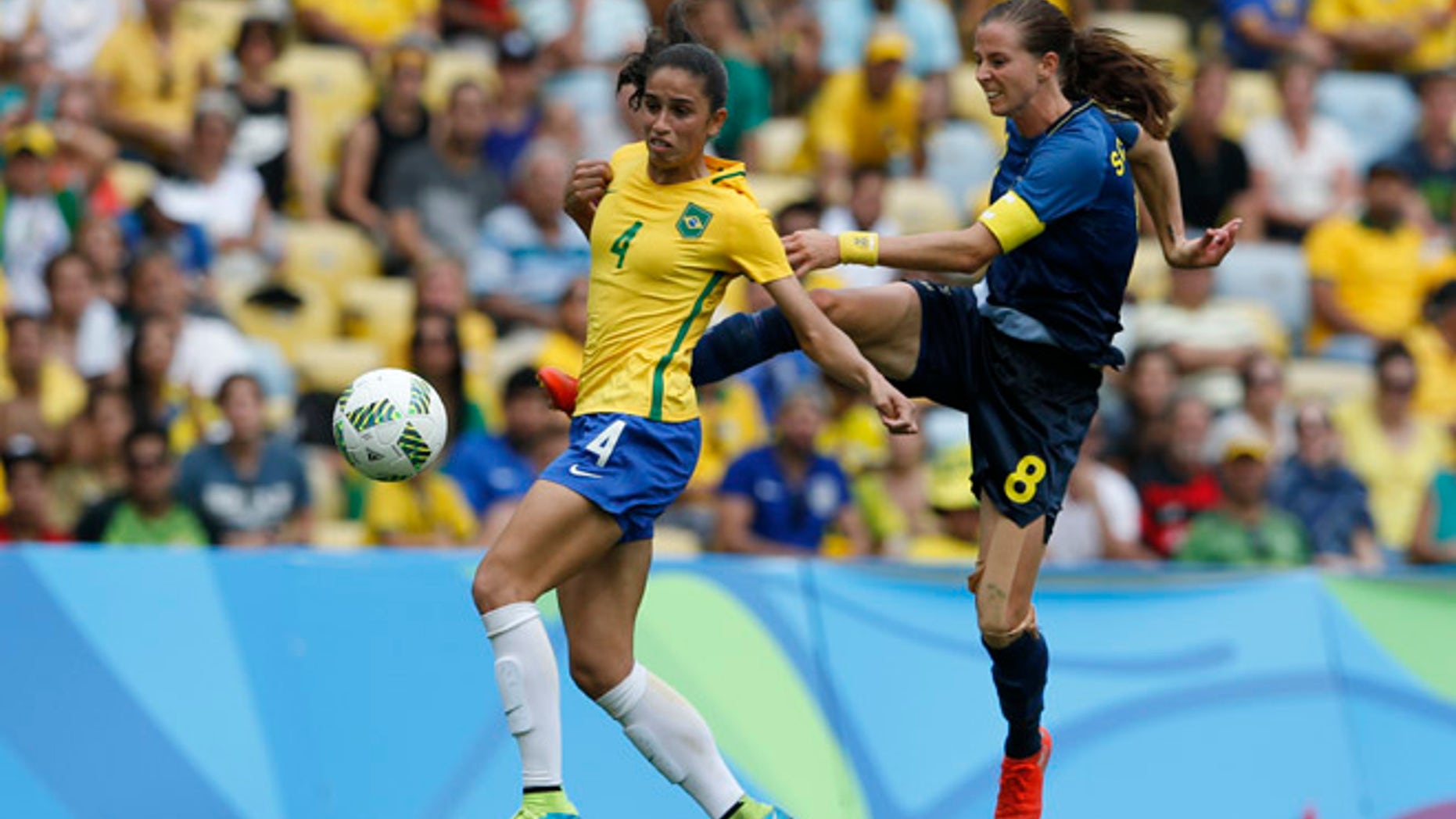 Sweden's Lotta Schelin, right, kicks the ball challenged by Brazil's Rafaelle during a extra time of a semi-final match of the women's Olympic football tournament between Brazil and Sweden at the Maracana stadium in Rio de Janeiro, Brazil, Tuesday Aug. 16, 2016.