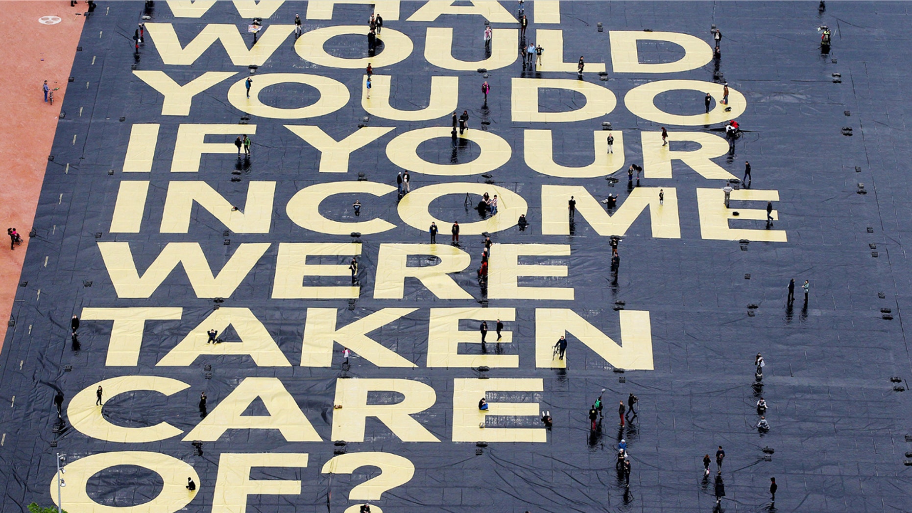 May 14, 2016: A huge poster reading 'What would you do if your income were taken care of?' is pictured on the Plaine de Plainpalais square in Geneva, Switzerland.