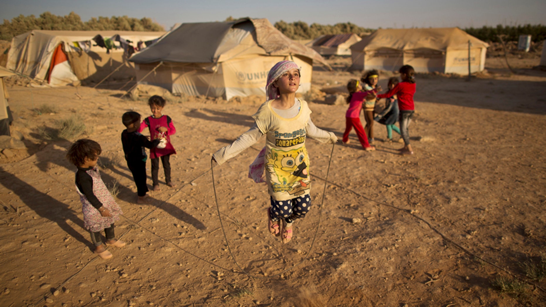 July 19, 2015: Syrian refugee girl, Zubaida Faisal, 10, skips a rope while she and other children play near their tents at an informal tented settlement near the Syrian border on the outskirts of Mafraq, Jordan.