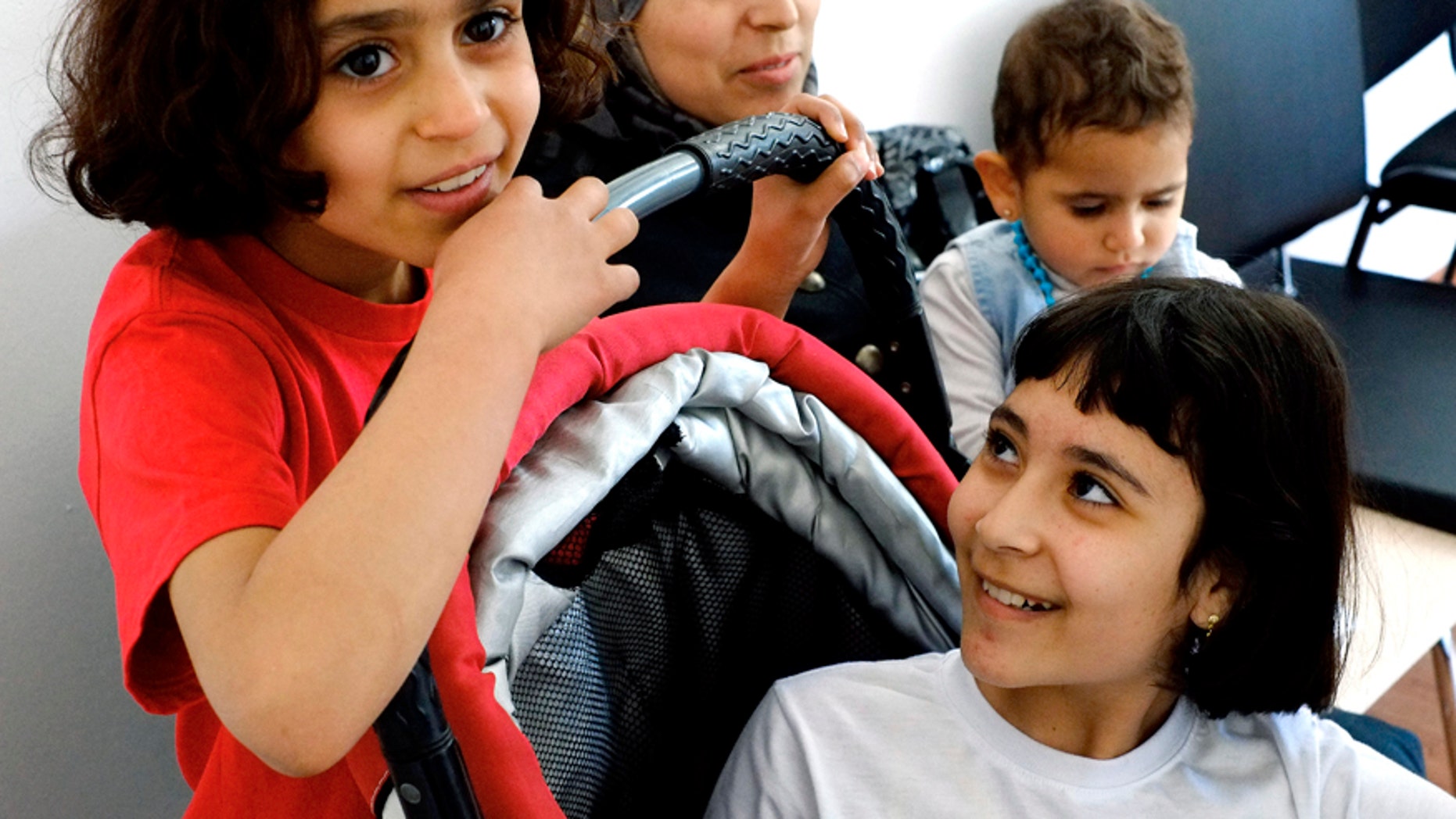 March 22, 2016: Eight-year-old Amal Ismail, left, with her older sister Alaa, right, and their younger 18-month-old Aryam are seen by their mother Maha at the IOM 'International Organization for Migration' office in capital Nicosia, Cyprus.