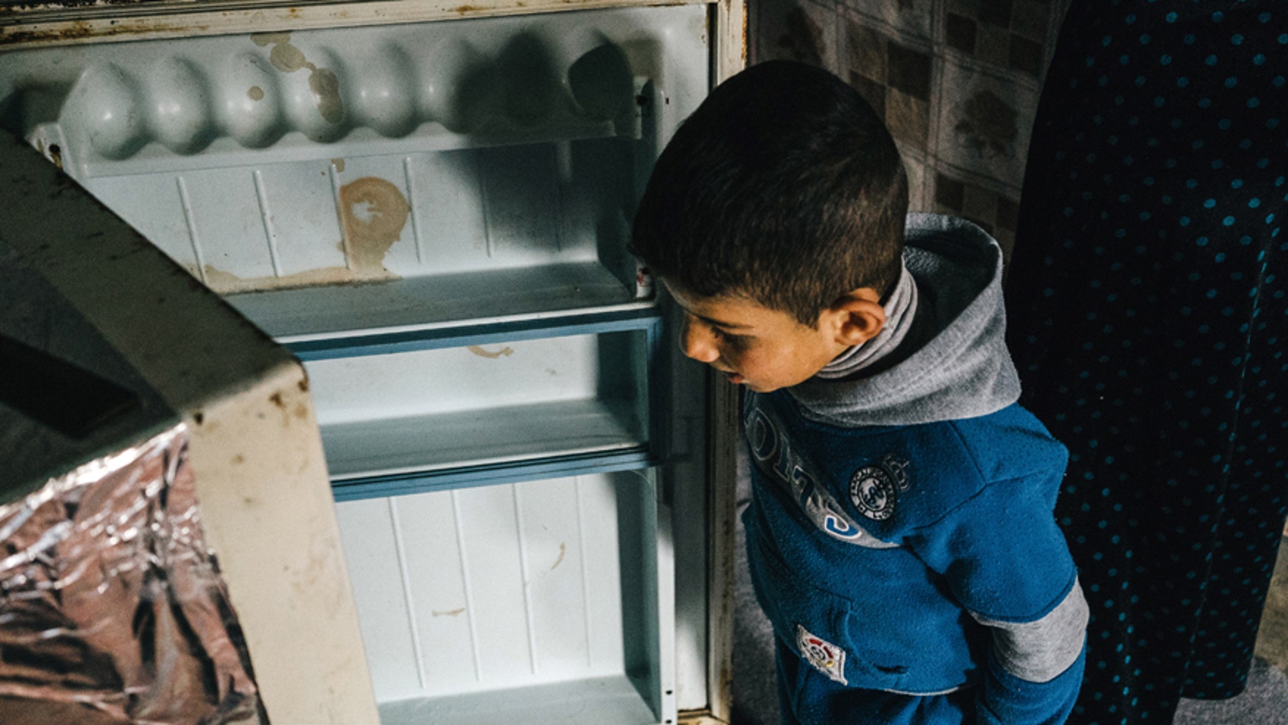 Jan. 24, 2016: A Syria refugee boy opens an empty fridge inside his family tent in Kawergosk refugee camp in northern Iraq.