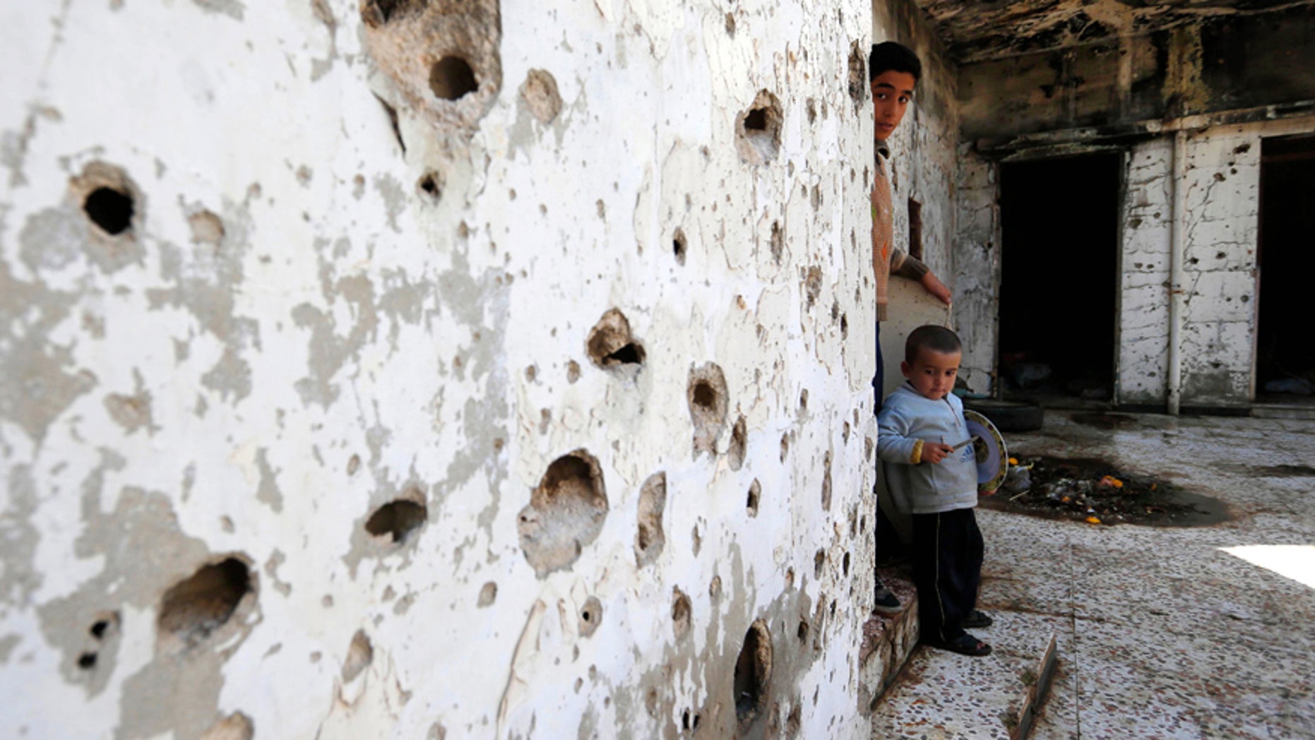 Feb. 26, 2016: Syrian boys are seen inside their destroyed house at neighborhood of Baba Amr in Homs, Syria.