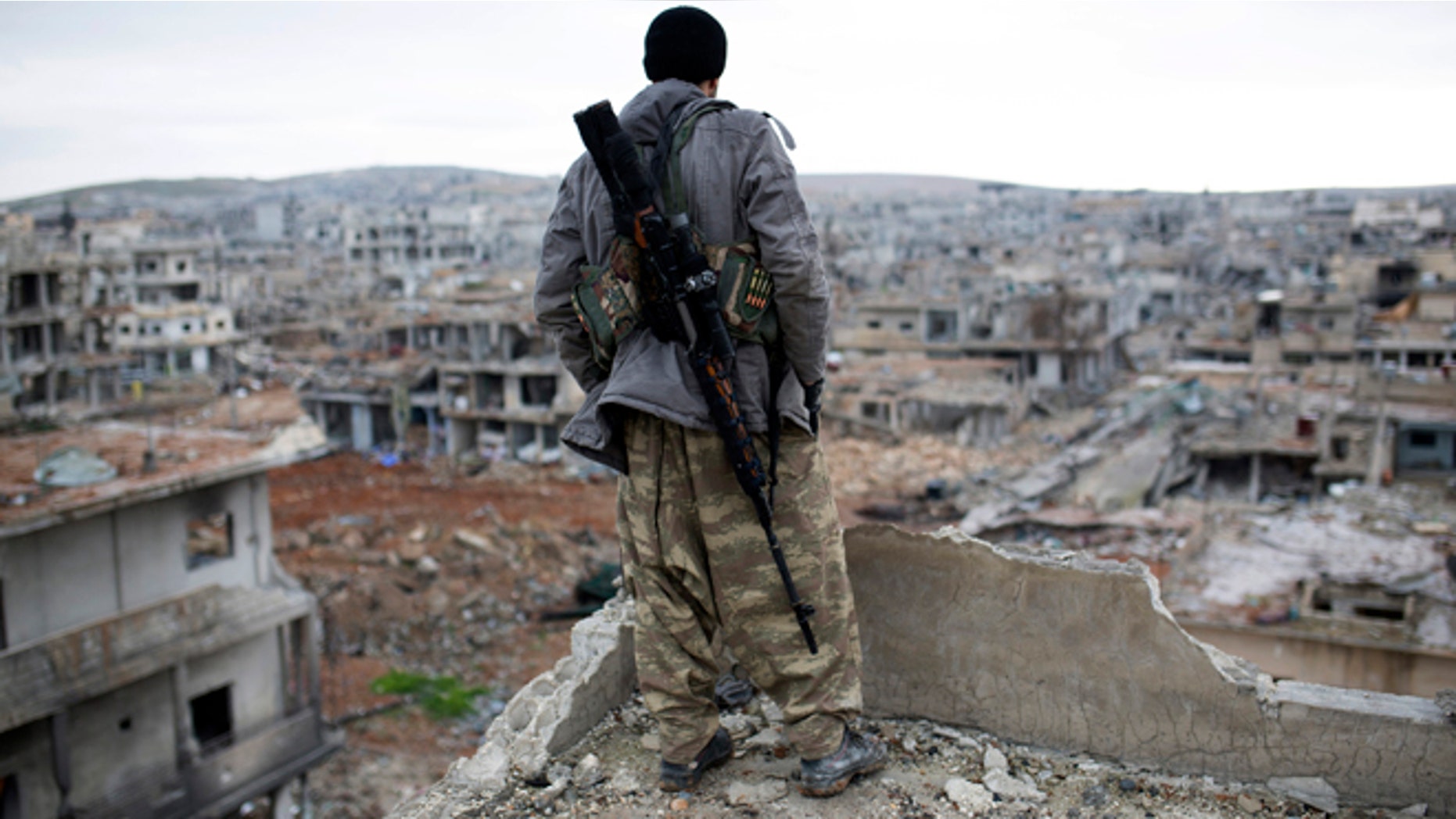 Jan. 30, 2015: In this file photo, a Syrian Kurdish sniper looks at the rubble in the Syrian city of Ain al-Arab, also known as Kobani. Fresh off a major victory in Kobani, Kurdish fighters in Syria have ambitions to become the chief force fighting Islamic State group extremists in the country - building on their victory in Kobani to ally with moderate rebels and push the jihadis ever further.