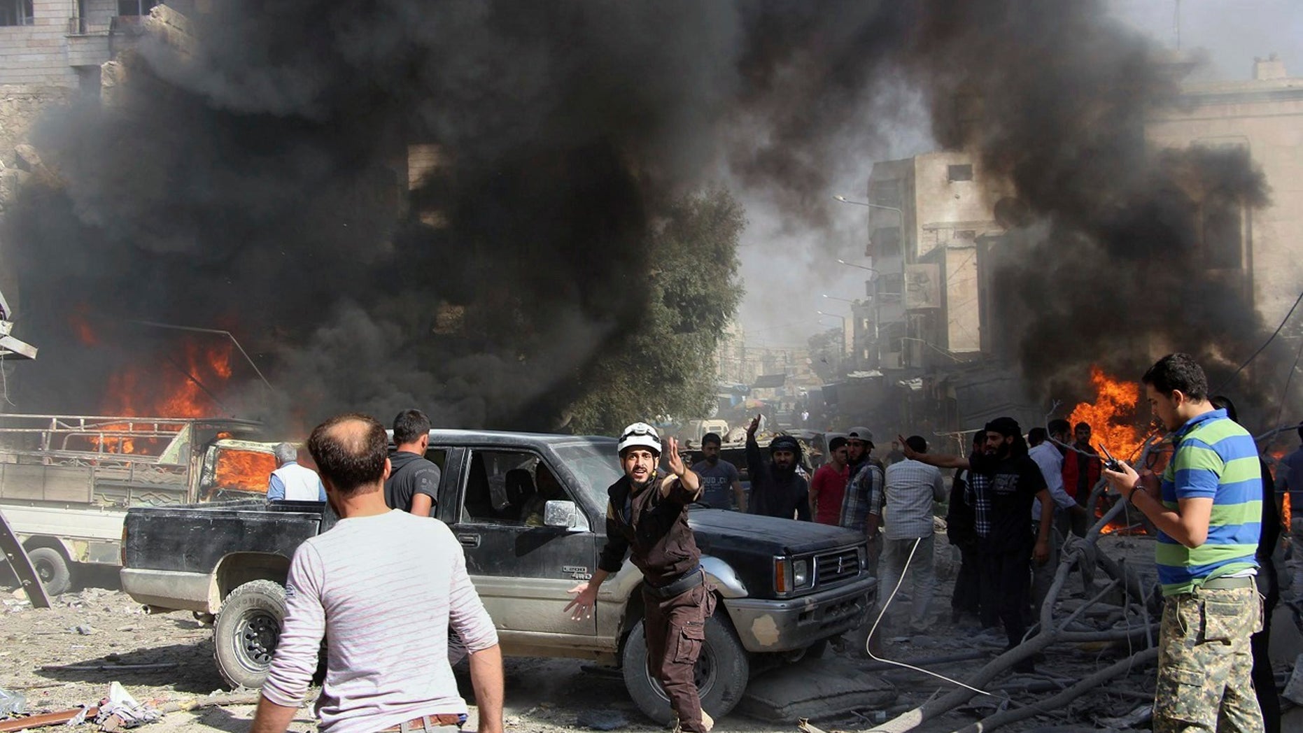 This file photo provided Sunday, Oct. 8, 2017 by the Syrian Civil Defense White Helmets, which has been authenticated based on its contents and other AP reporting, shows Civil Defense workers and Syrian citizens gathering after an airstrike hit a market in Maaret al-Numan in southern Idlib, Syria.