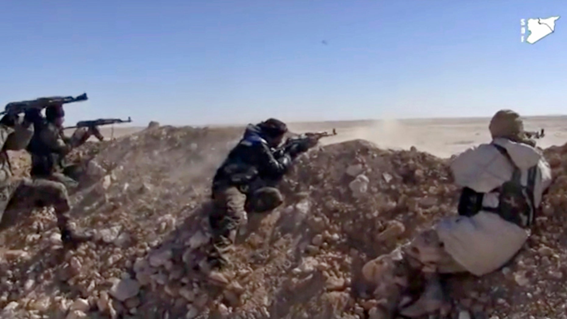 FILE - This frame grab from a March 6, 2017 video provided by the Syria Democratic Forces (SDF), shows fighters from the SDF opening fire on a position of the Islamic State group in the countryside east of Raqqa, Syria. As the American backed SDF fighters bear down on Raqqa, the militants have trapped the citys estimated 300,000 residents to use as human shields, ringing the city with land mines to prevent escape. (Syria Democratic Forces, via AP, File)