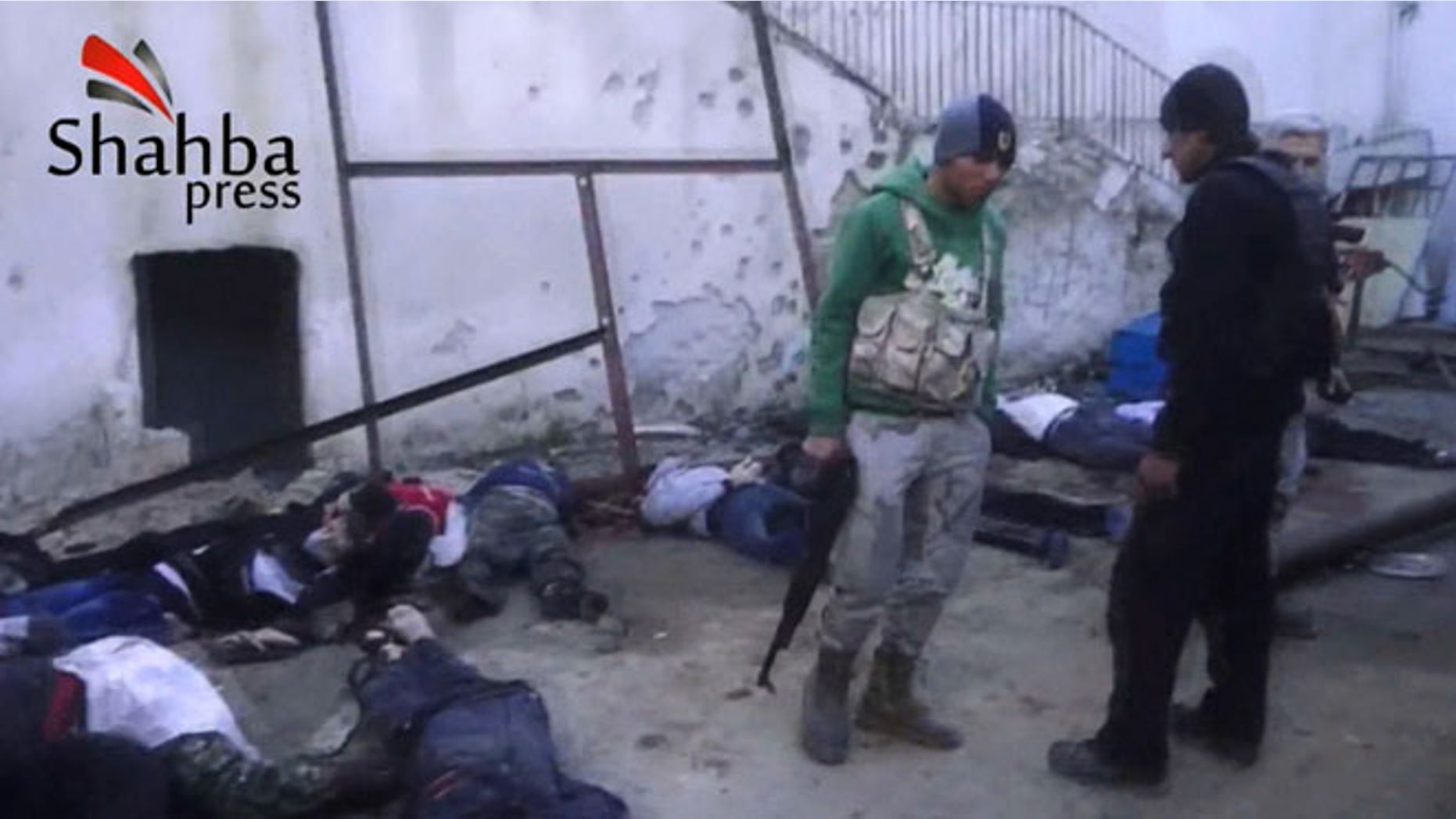 This image made from citizen journalist video posted by the Shahba Press on Wednesday, Jan. 8, 2014, which has been verified and is consistent with other AP reporting, shows rebel fighters standing next to dead bodies after they ousted Islamic State of Iraq and the Levant (ISIL) from their headquarters in a hospital in the Syrian city of Aleppo. Activists said the people were killed by fighters from the Al Qaeda affiliate, which is trying to build Islamic rule across Syria.
