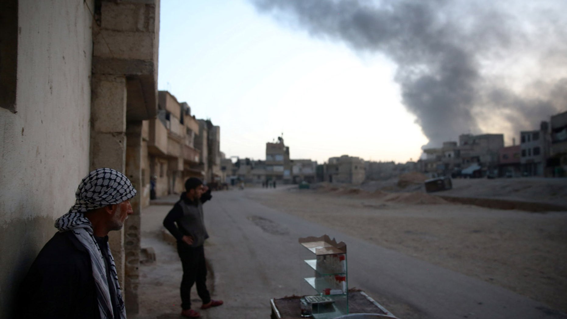 Syrian residents watch as smoke rises from Harasta area, as seen from Douma, in the eastern Damascus suburb of Ghouta, Syria November 14, 2017. REUTERS/Bassam Khabieh - RC1B753E7E30