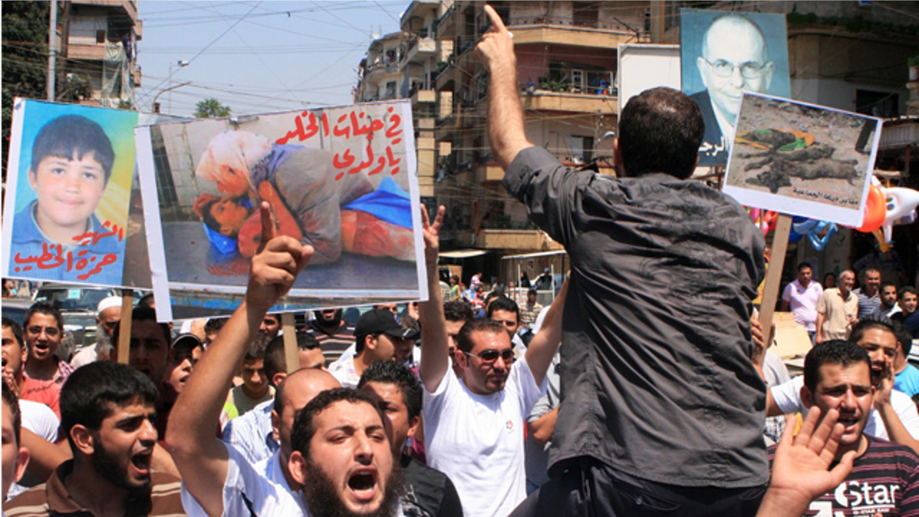 July 15: Lebanese protesters shout slogans as they carry banners in Arabic that read:" you are in heaven my son," center, "the martyr Hamza el-Khatib," left, and "Daraa mass graves," right, during a rally in solidarity with Syrian anti-government protesters in the northern city of Tripoli, Lebanon. Syrian security forces fired on protesters in the capital and other major cities Friday, killing at least 14 people as hundreds of thousands gathered for some of the largest anti-government rallies since the uprising began in March, witnesses and activists said.