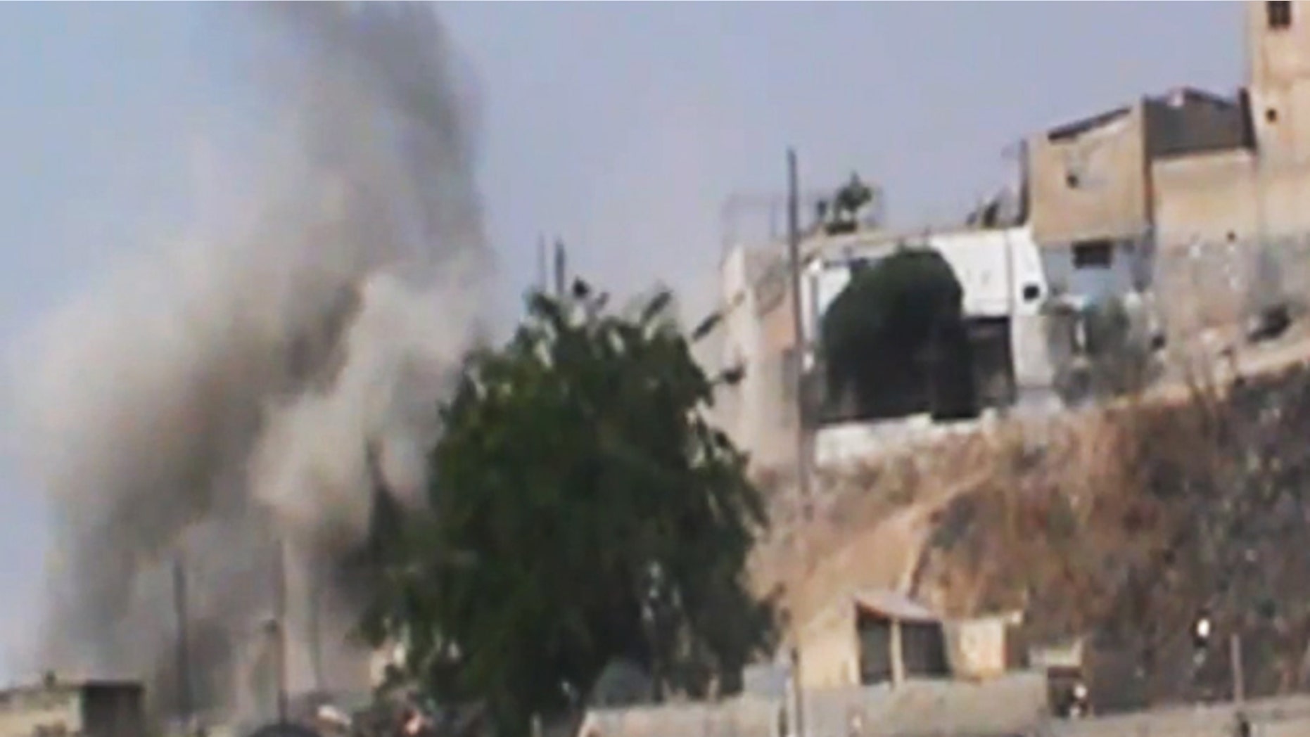 This image made from amateur video released by the Shaam News Network and accessed Wednesday, June 20, 2012, purports to show smoke rising from buildings in Homs province, Syria.