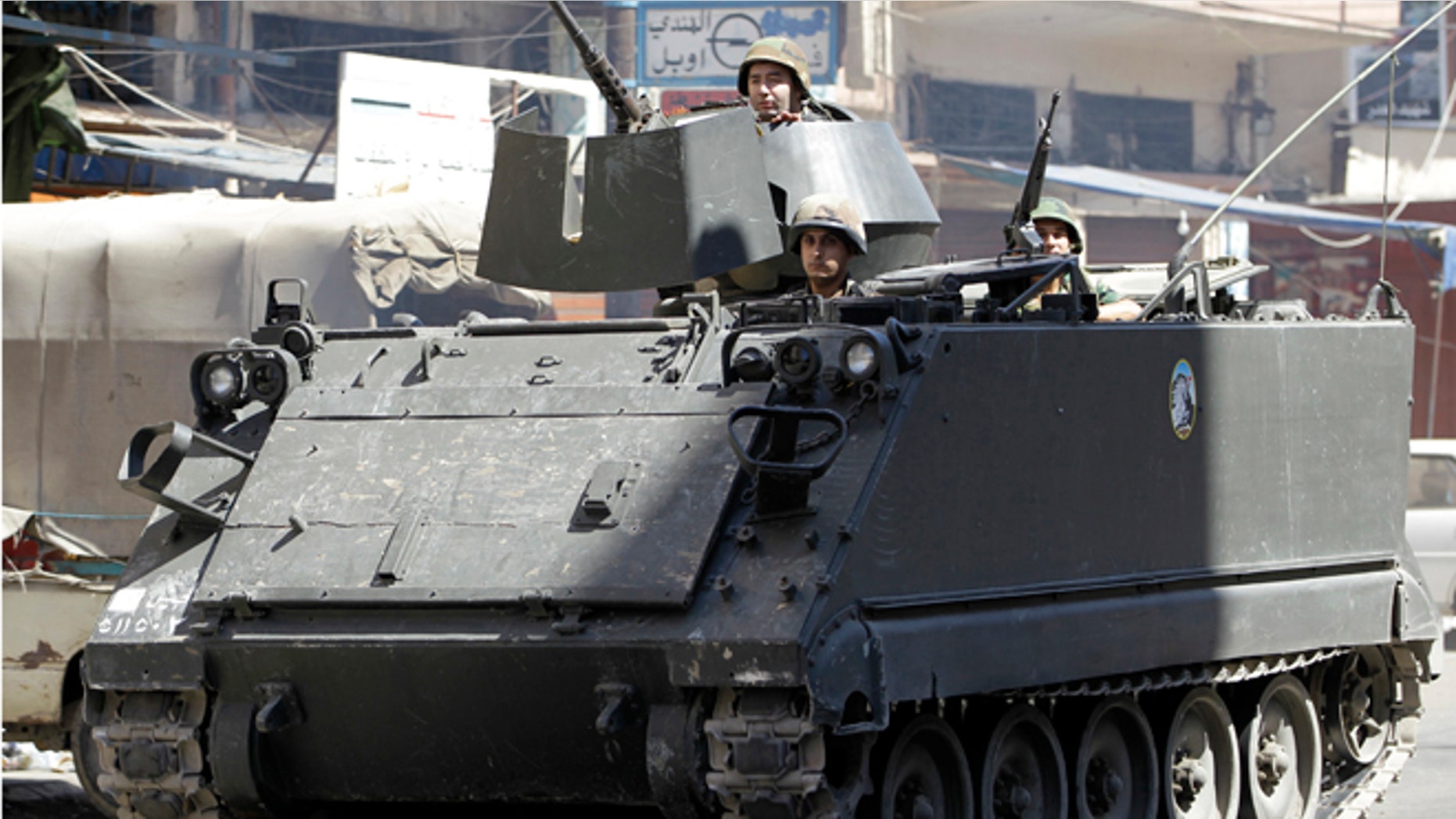 August 22, 2012: Lebanese army soldiers in a armored personnel carrier pass Syria street, which divides areas between supporters and opponents of the Syrian regime, in the northern port city of Tripoli, Lebanon.
