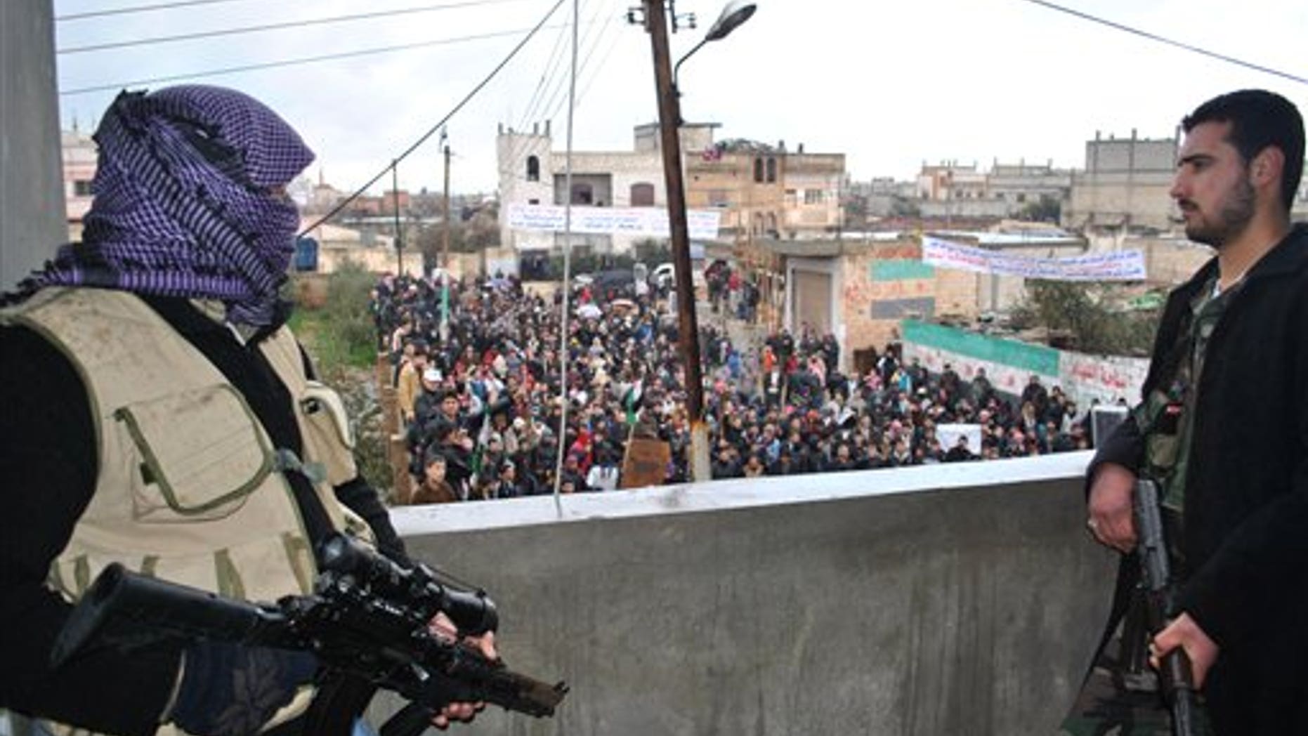 Jan. 27, 2012: Syrian army defectors stand guard on a rooftop to secure an anti-Syrian regime protest in the Deir Baghlaba area in Homs province, central Syria. Armed forces loyal to President Bashar Assad barraged residential buildings with mortars and machine-gun fire, killing at least 30 people, including a family of women and children during a day of sectarian killings and kidnappings in the besieged Syrian city of Homs, activists said Friday.