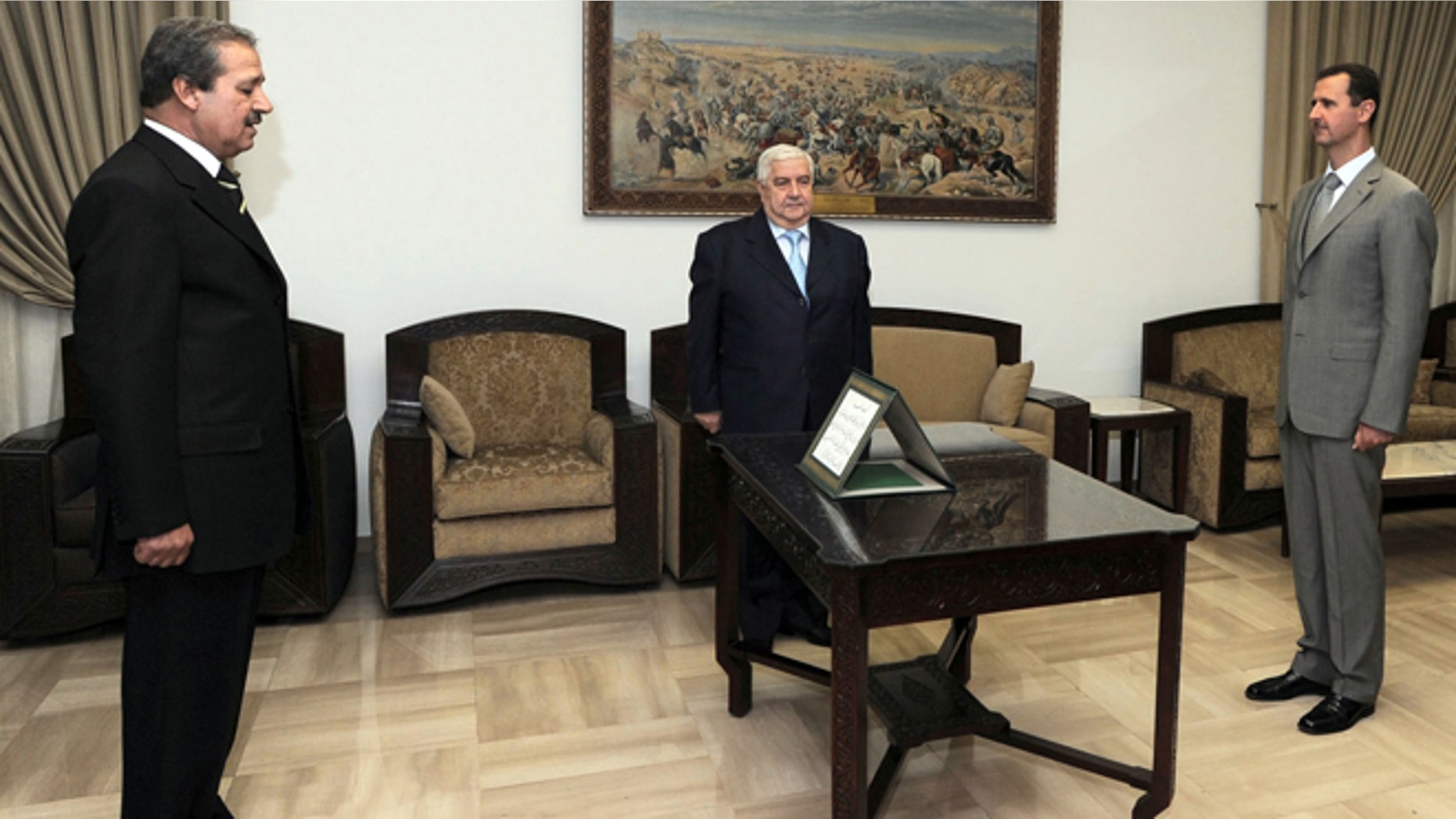 FILE - In this Sept. 16, 2008 file photo provided by the Syrian official news agency SANA, Nawaf Fares, left, is sworn in as Syria's first ambassador to Iraq in 26 years before Syrian President Bashar Assad, right, and Syrian Foreign Minister Walid Moallem in Damascus.