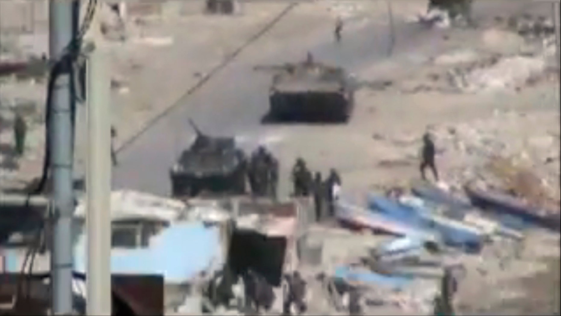 Aug. 17: This image taken from amateur video made available Tuesday purports to show armored vehicles and troops in Latakia, Syria on Monday. Activists say 15 people died in shootings across Syria Monday including at least five in the coastal city of Latakia where military operations where in their fourth day.