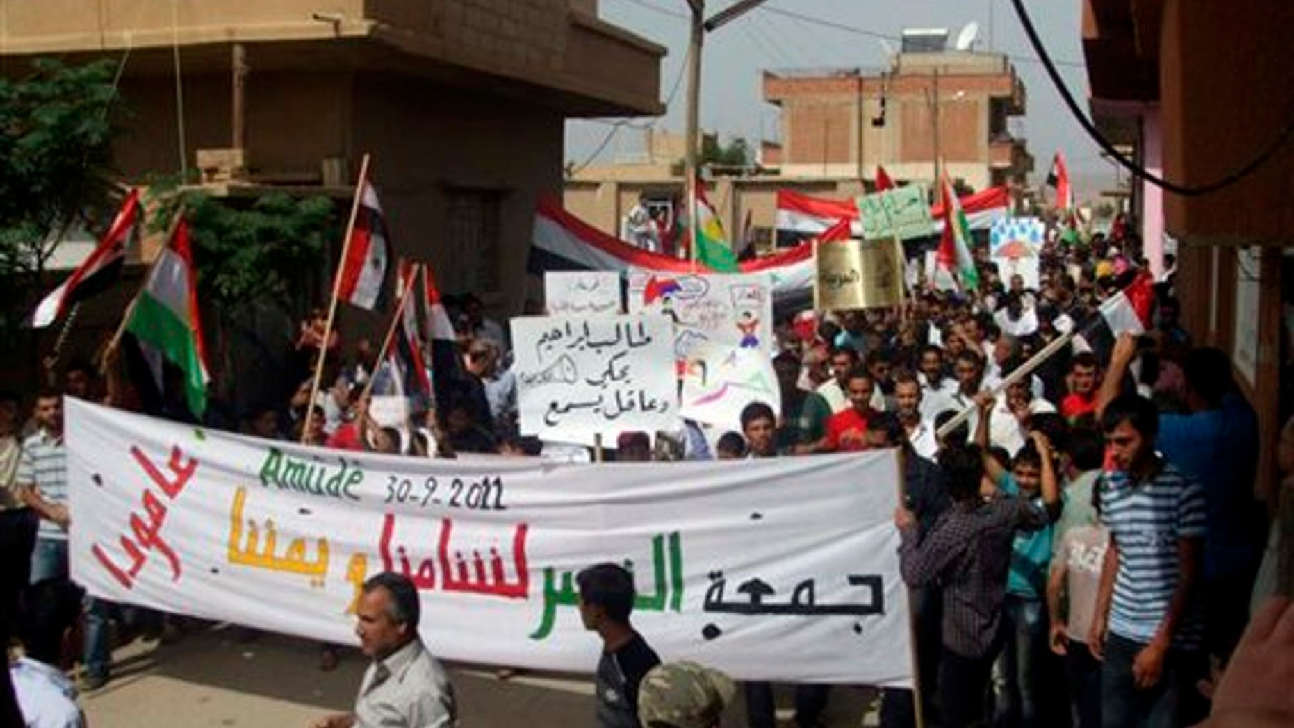 Sept. 30: In this citizen journalism image made on a mobile phone and provided by Shaam News Network, anti-Syrian President Bashar Assad protesters march during a demonstration against the Syrian regime, at the Kurdish-Syrian village of Amouda, in Kamishli province.