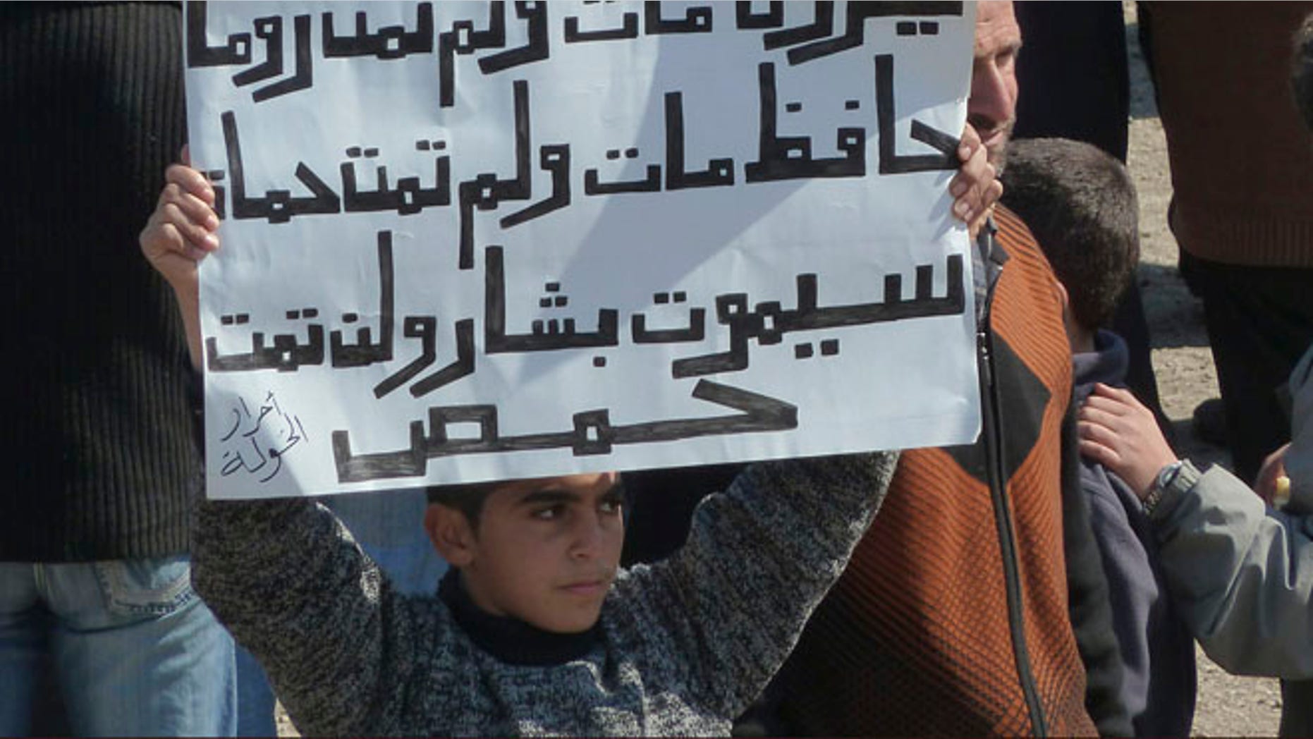 March 2: A boy holds up a placard during a demonstration against Syria's Assad near the city of Homs that reads: 'Nero died, Rome did not die, Hafez died, Hama did not die, Bashar will die, Homs will not die.'