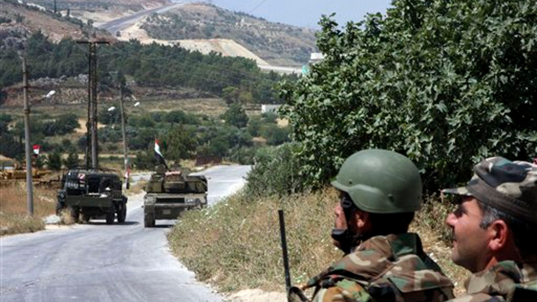 June 11: In this photo taken during a government-organized tour for the media, Syrian soldiers and armored vehicles arrive in Istabraq village near the northern town of Jisr al-Shughour, Syria. A border region with a history of hostility toward the Syrian regime is posing the biggest challenge yet for President Bashar Assad's struggle to crush the revolt against his family's 40-year-rule. (AP)