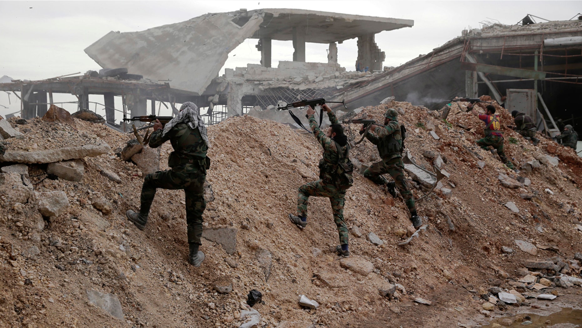 Syrian army soldiers fire their weapons during a battle with rebels at the Ramouseh front line, east of Aleppo, Syria, Monday, Dec. 5, 2016.