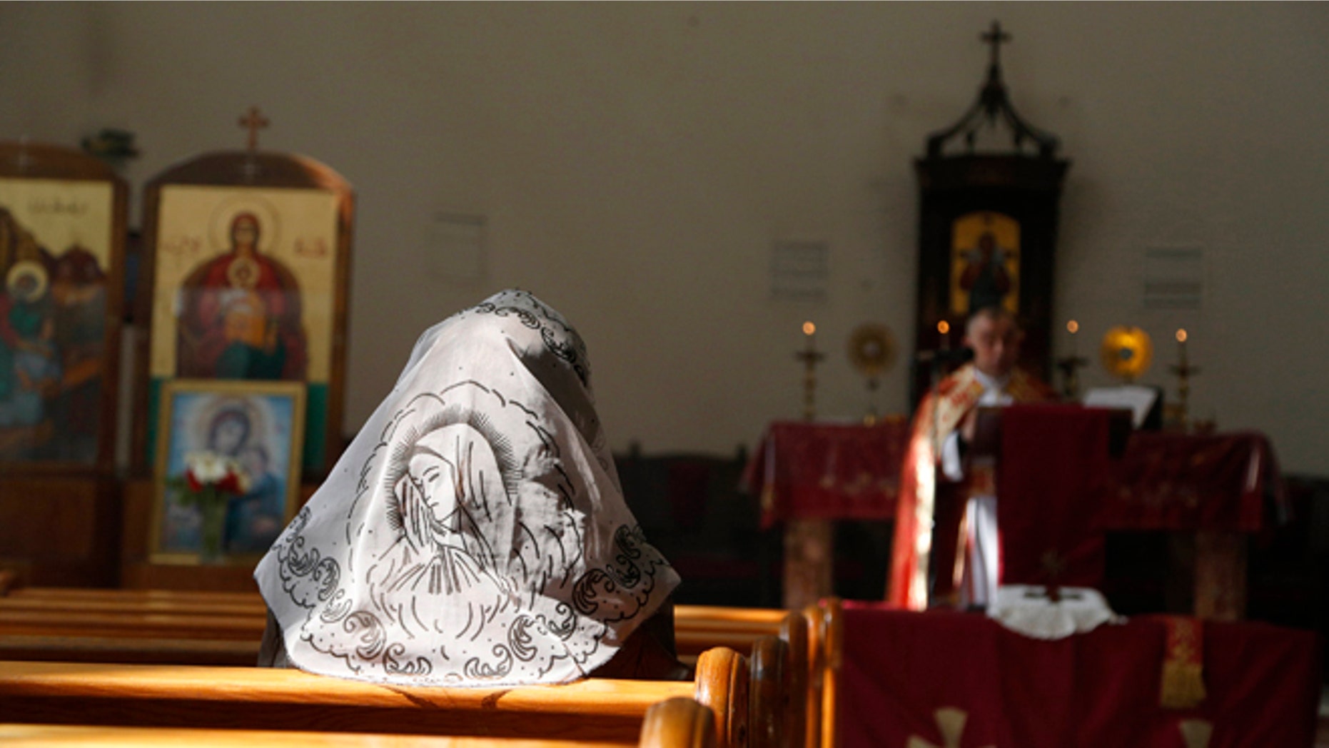 FILE: An Assyrian woman attends a mass in solidarity with the Assyrians abducted by Islamic State fighters in Syria earlier the inside Ibrahim al-Khalil church in Jaramana, eastern Damascus on March 1, 2015.