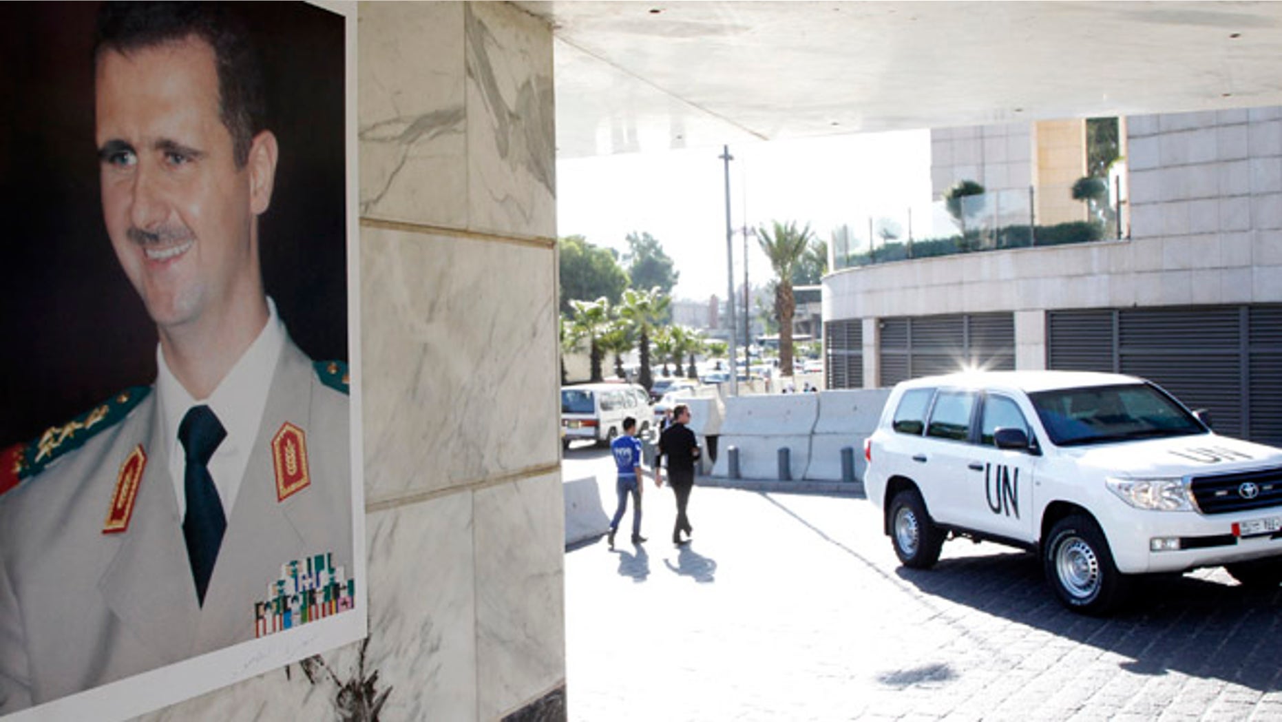 Oct. 8, 2013: A U.N. vehicle is seen near a photo of Syrian President Bashar al-Assad at the entrance of a hotel where a team of experts from the Organisation for the Prohibition of Chemical Weapons (OPCW) were staying in Damascus. (Reuters)