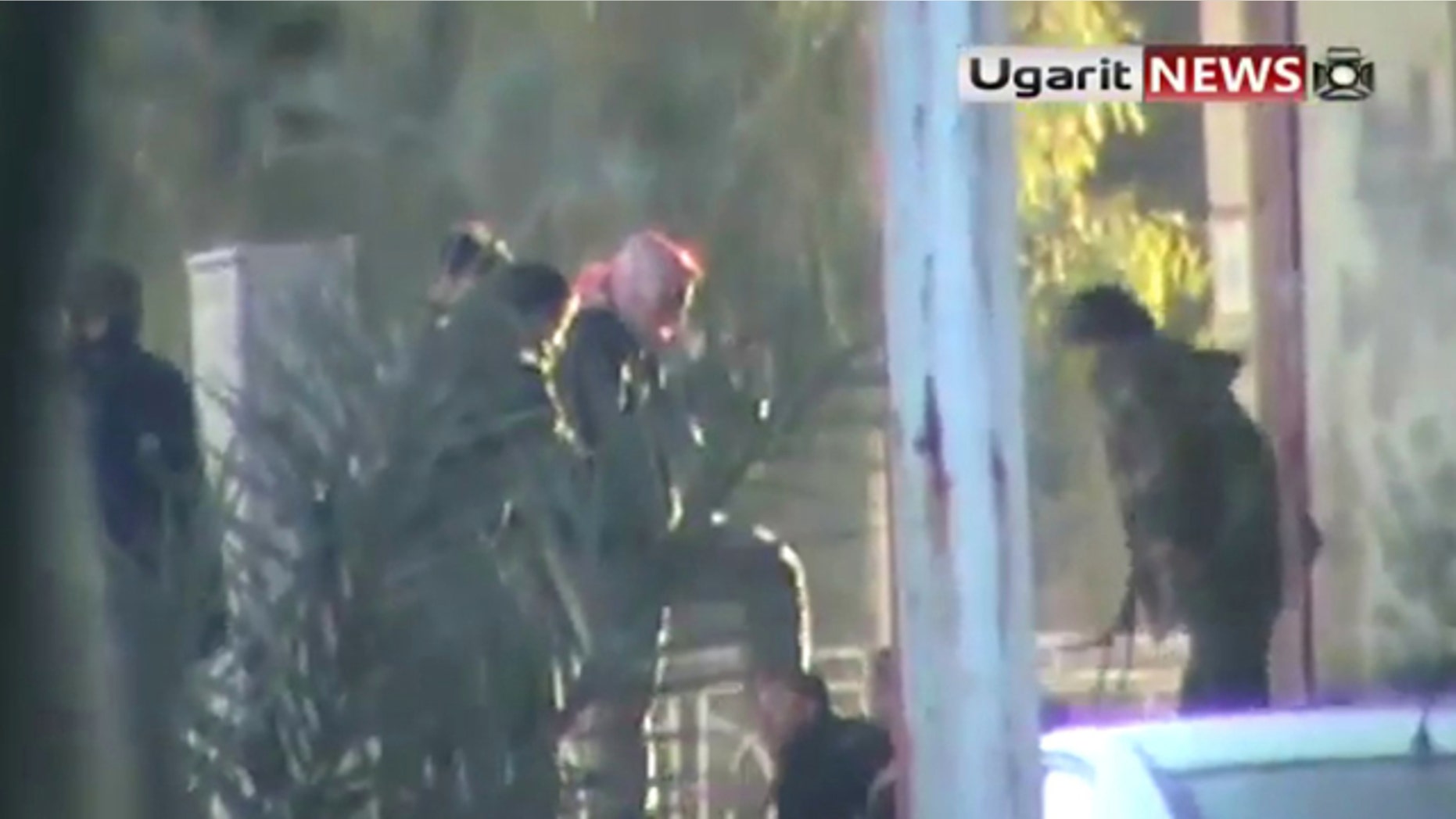 Dec. 12: This image from amateur video made available by the Ugarit News group purports to show a man being kicked by a group of soldiers in Hama, Syria.