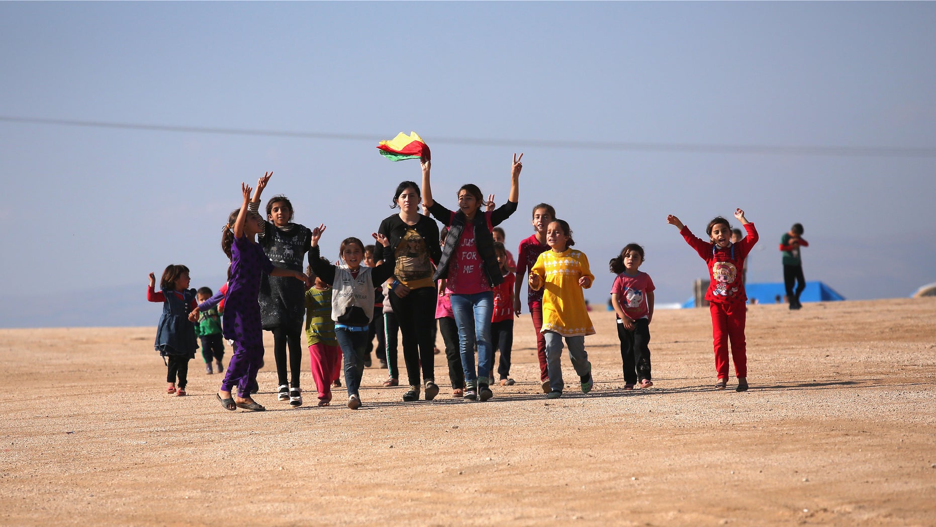 DEREK, SYRIA - NOVEMBER 13: Yazidi refugees celebrate news of the liberation of their homeland of Sinjar from ISIL extremists, while at a refugee camp on November 13, 2015 in Derek, Rojava, Syria. Kurdish Peshmerga forces in Iraq say they have retaken Sinjar, with the help of airstrikes from U.S. led coalition warplanes. The Islamic State captured Sinjar in August 2014, killing many and sexually enslaving thousands of Yazidi women. (Photo by John Moore/Getty Images)