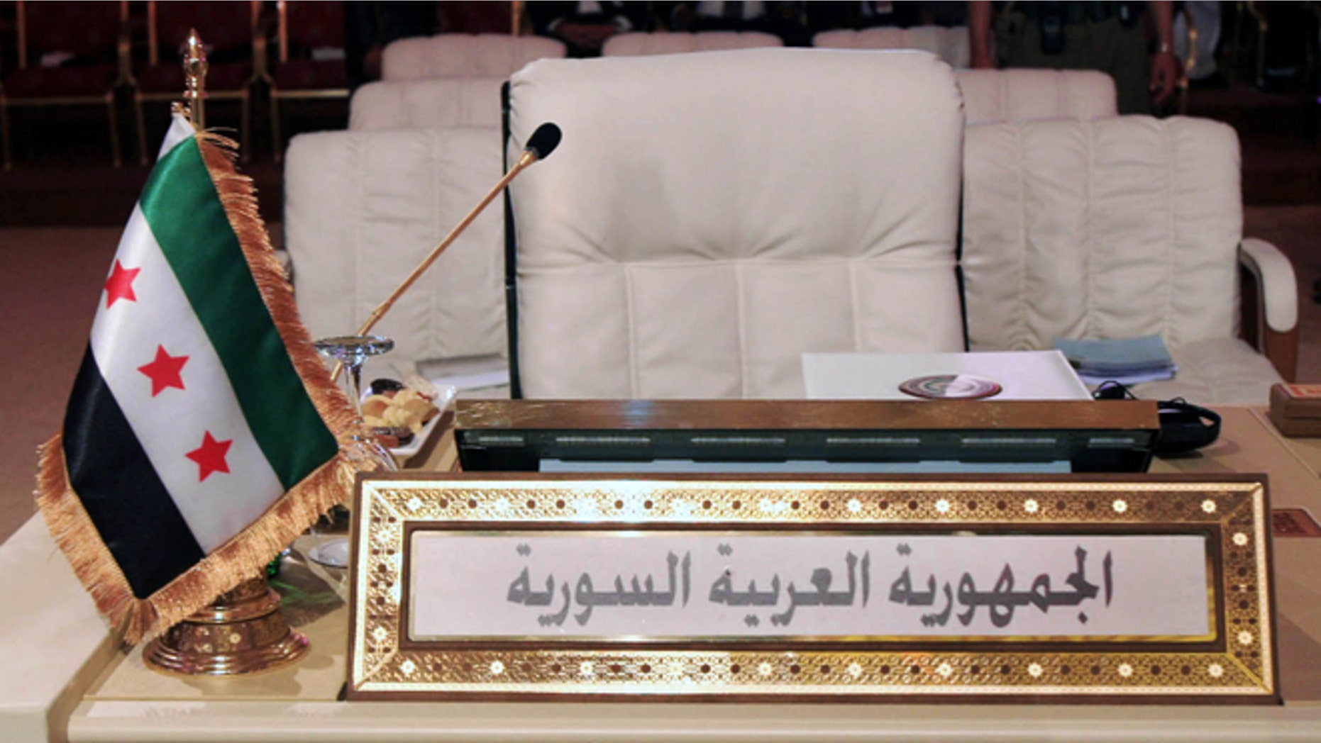 March 26, 2013: The Syrian revolutionary flag, is seen in front of the empty seat of the Syrian delegation during the opening session of the Arab League summit in Doha, Qatar. Syrian opposition representatives took the country's seat for the first time at an Arab League summit that opened in Qatar on Tuesday, a significant diplomatic boost for the forces fighting President Bashar Assad's regime.