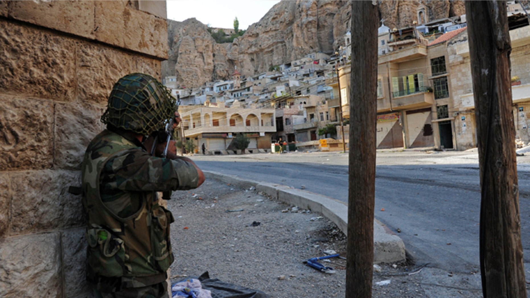 Sept. 11, 2013: In this photo released by the Syrian official news agency SANA, a Syrian government solider aims his weapon during clashes with Free Syrian Army fighters, not pictured, in Maaloula village, northeast of the capital Damascus, Syria.