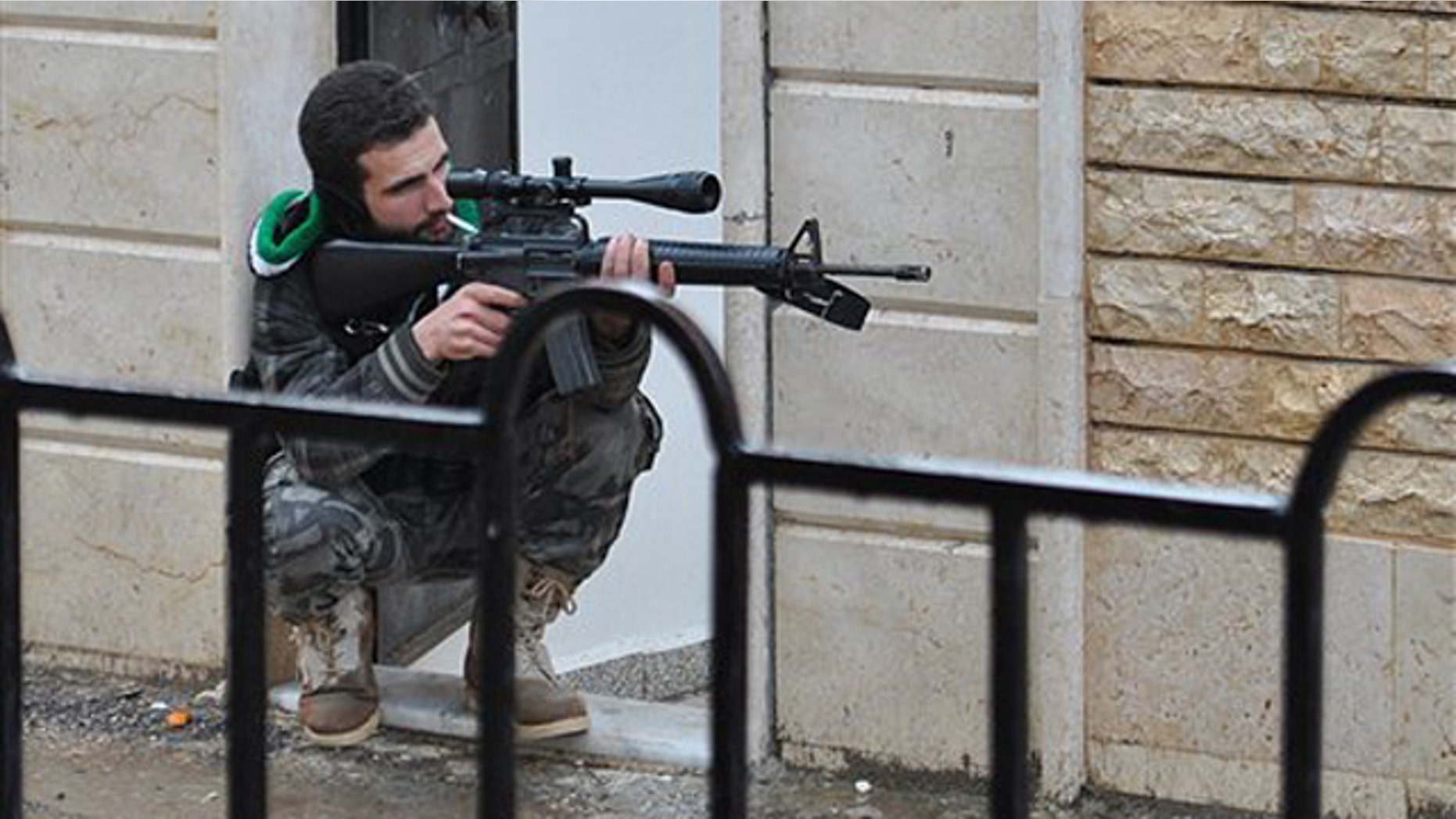 Jan. 31, 2012: A Syrian rebel takes his position as he points his gun during a battle with the Syrian government forces, at Rastan area in Homs province, central Syria.